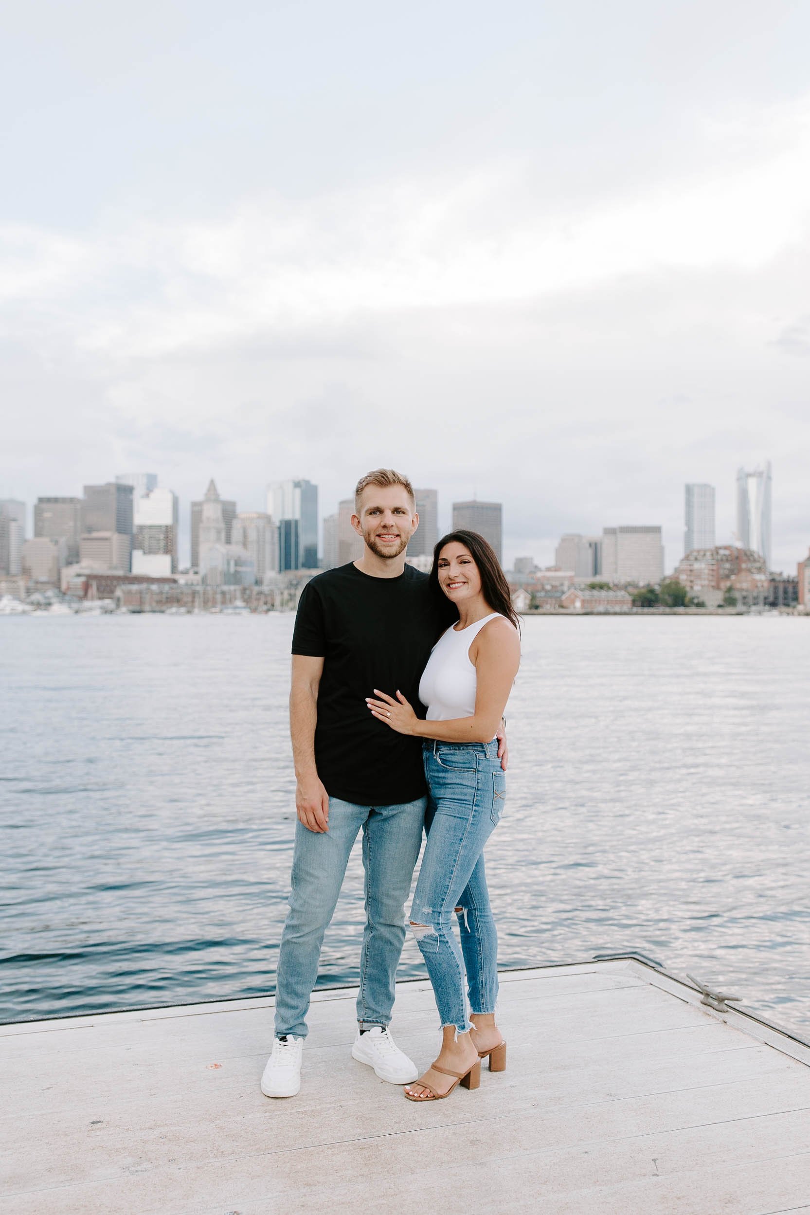  Engaged couple smiling standing in front of skyline view  