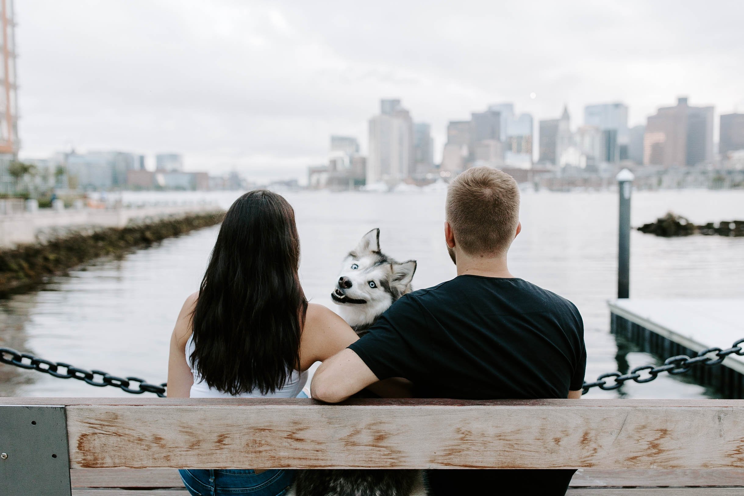 Engaged couple looking out at the oceanfront skyline view in Boston