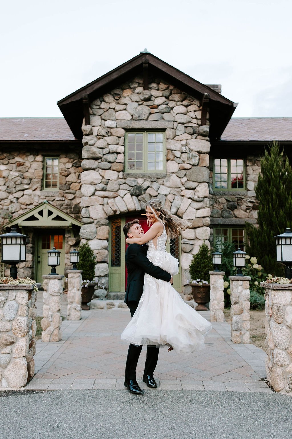 Bride and groom kissing in front of willowdale estate