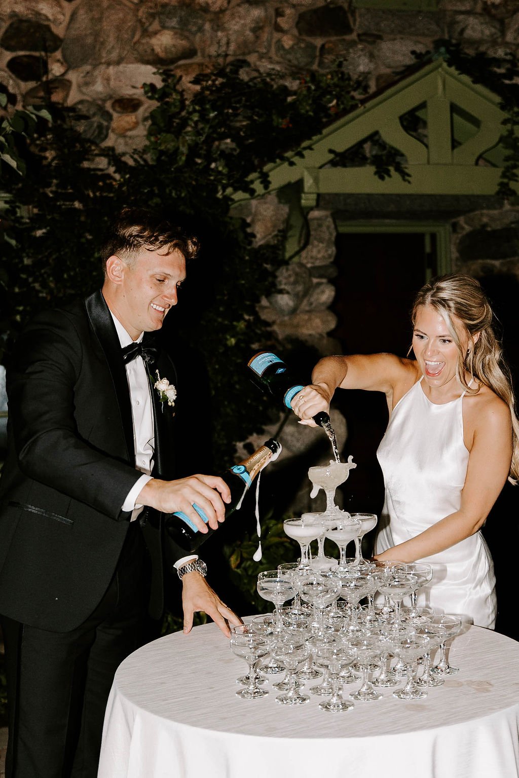 Bride and groom pouring champagne on champagne tower