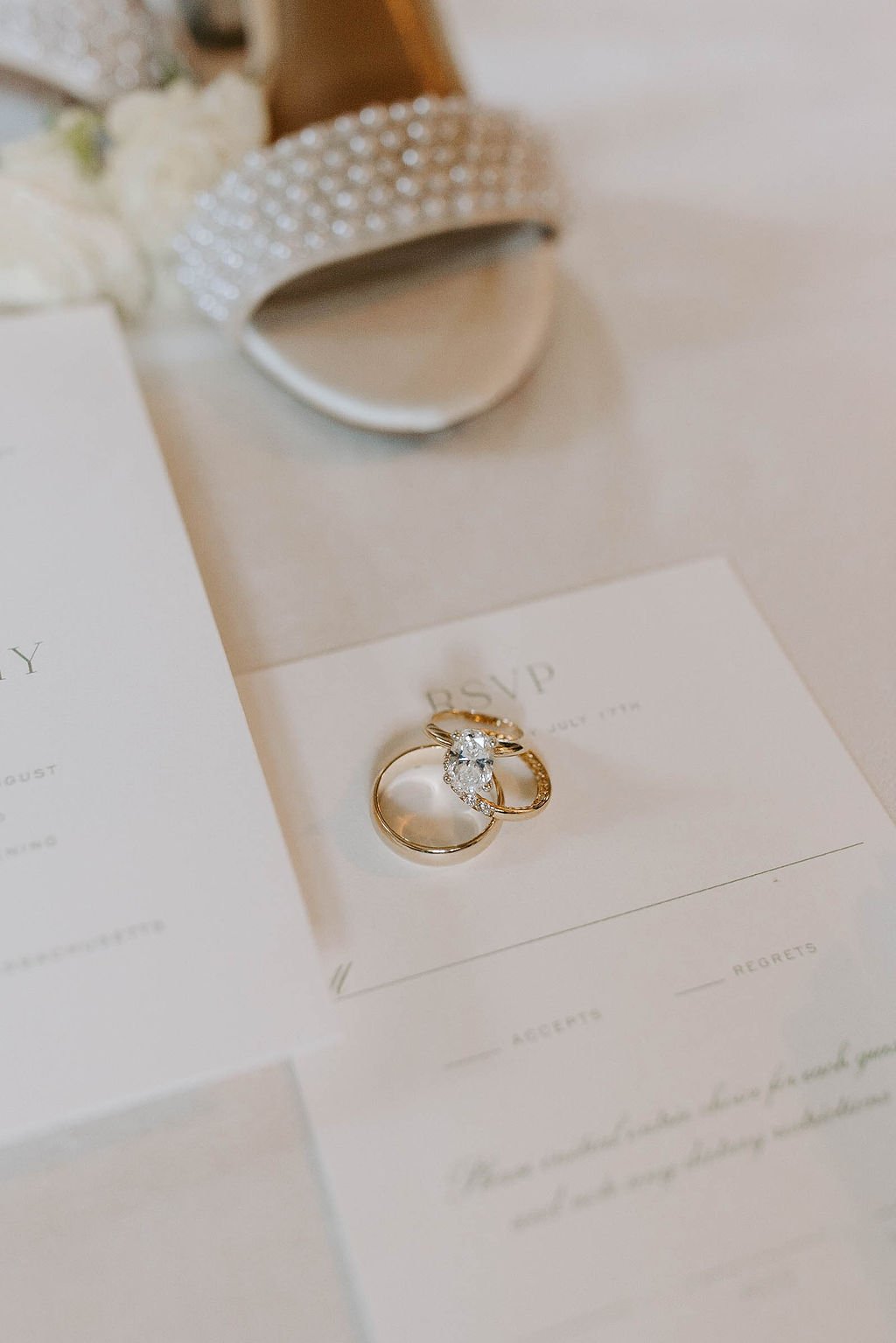 Wedding details of wedding flaylay, white heel, and wedding ring