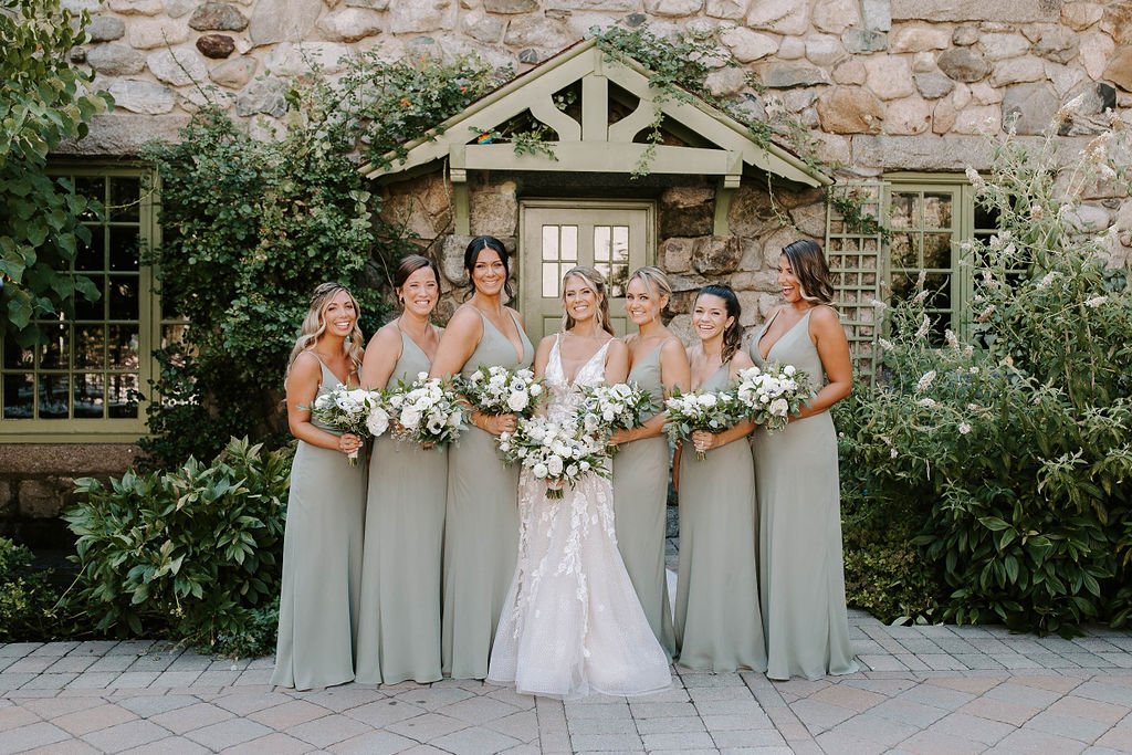 Bride and bridesmaids smiling and posing in front of Willowdale Estate