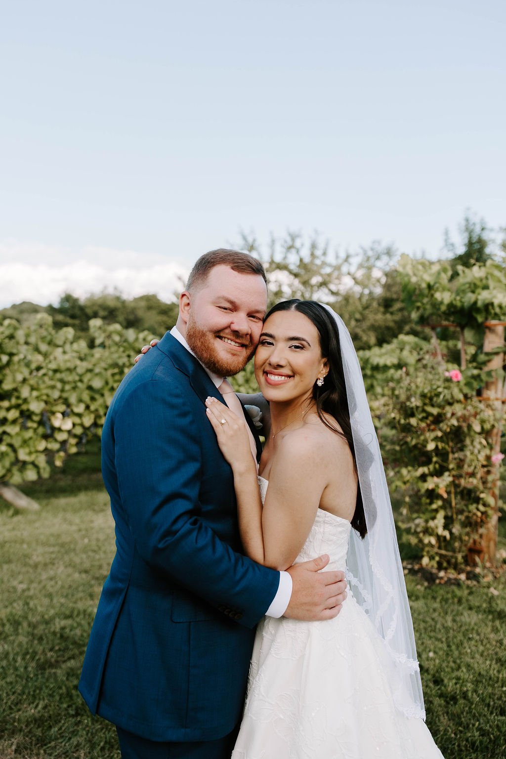 Bride and groom smiling holding one another in vineyards