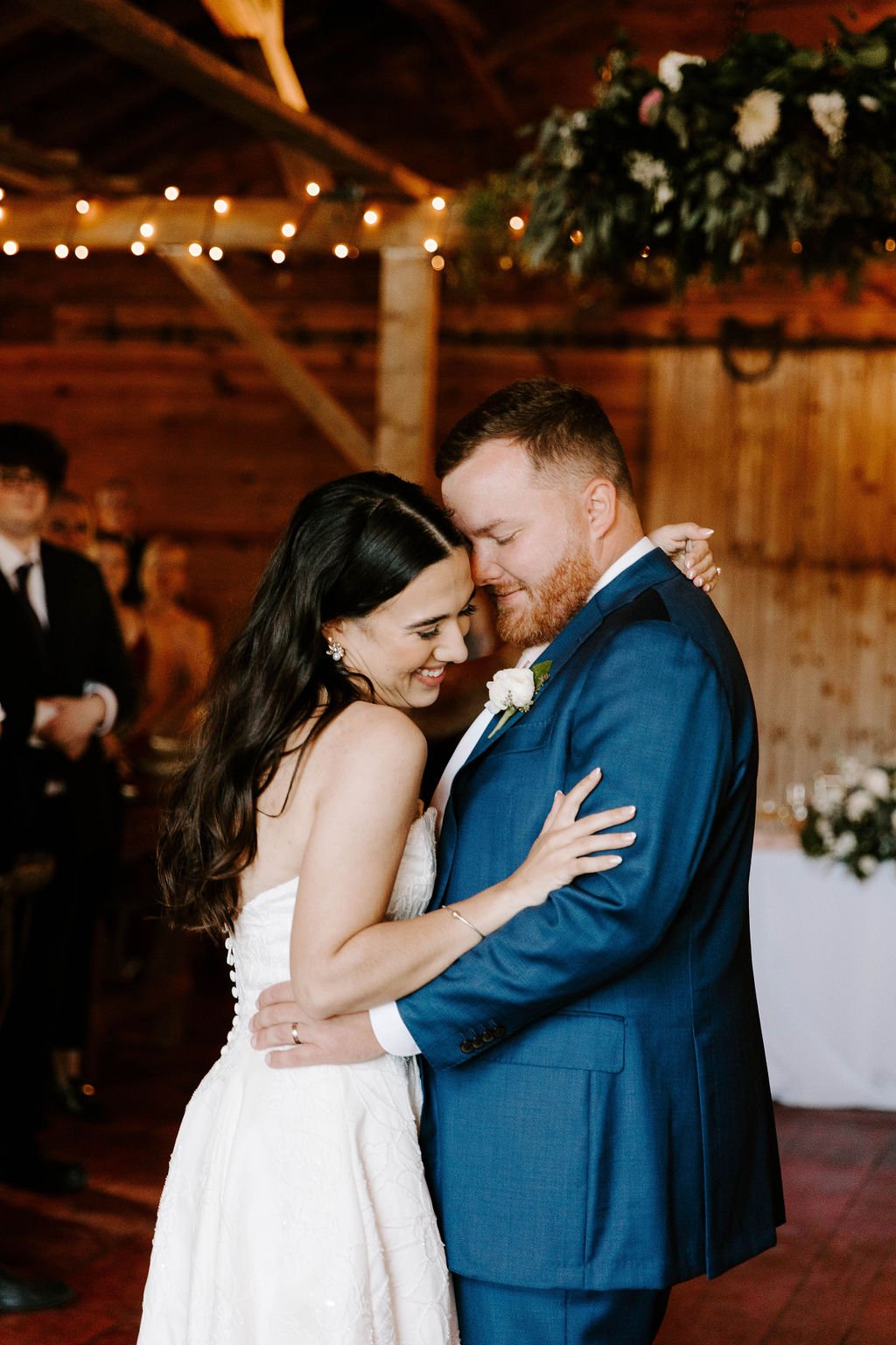 Bride and groom dancing close to one another smiling and laughing