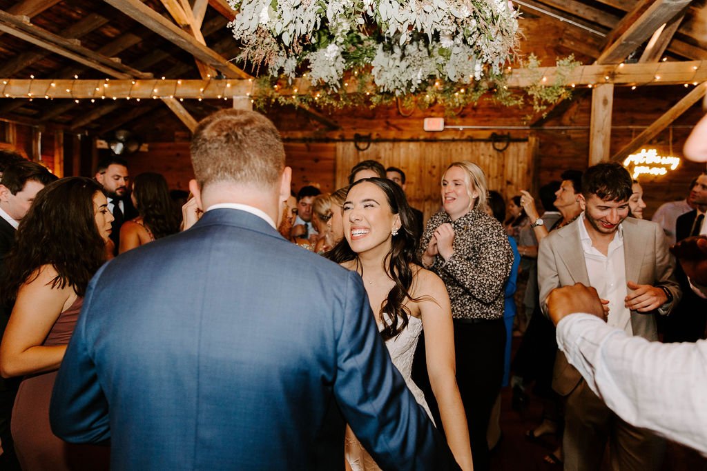 Bride and groom dancing on dance floor while bride is looking at the groom smiling
