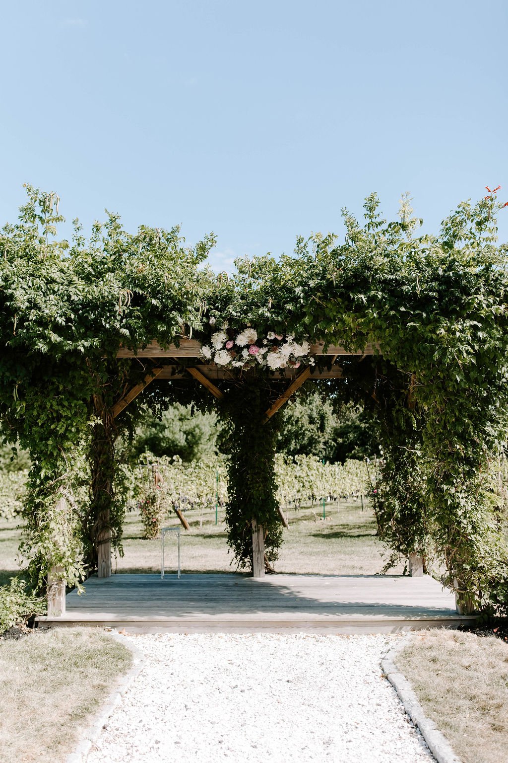  Ceremonial arch covered in green vines and floral arrangements 