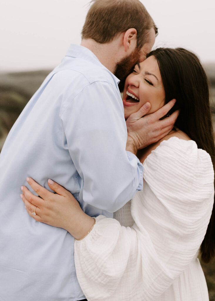 Man and woman laugh during Gloucester engagement session