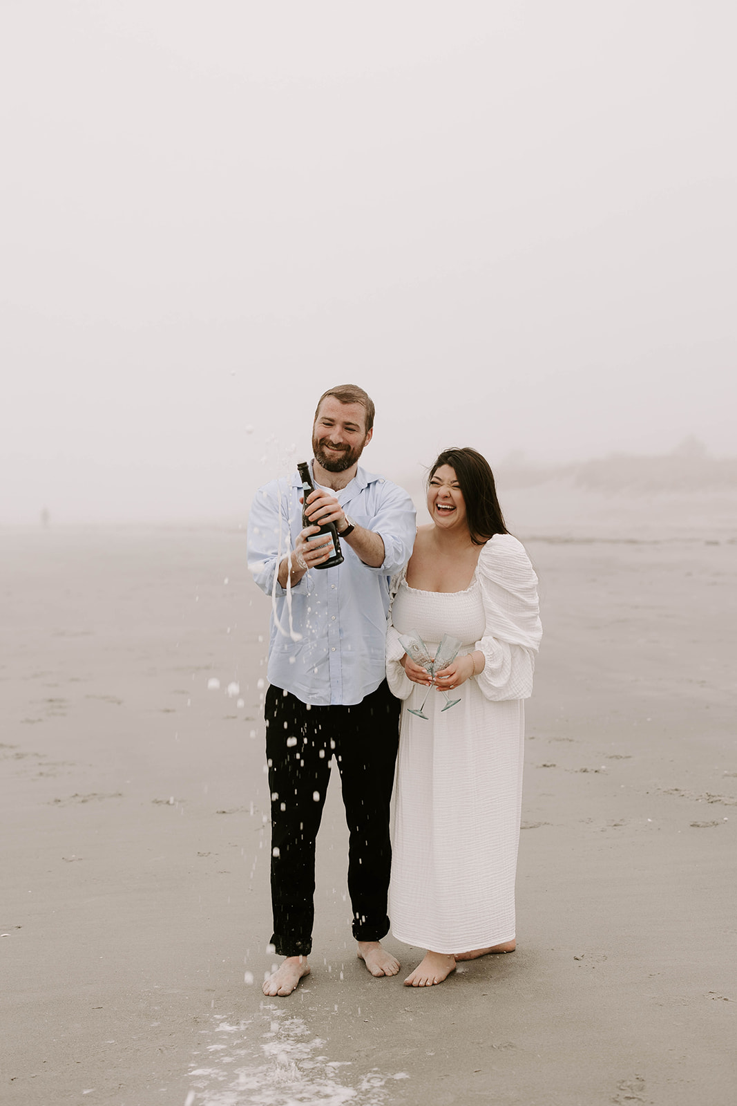 Man and woman pop champagne during Wingaersheek Beach pictures