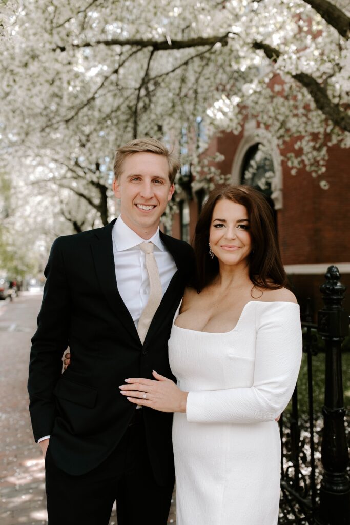 The bride and groom smile at the camera before their Boston elopement ceremony