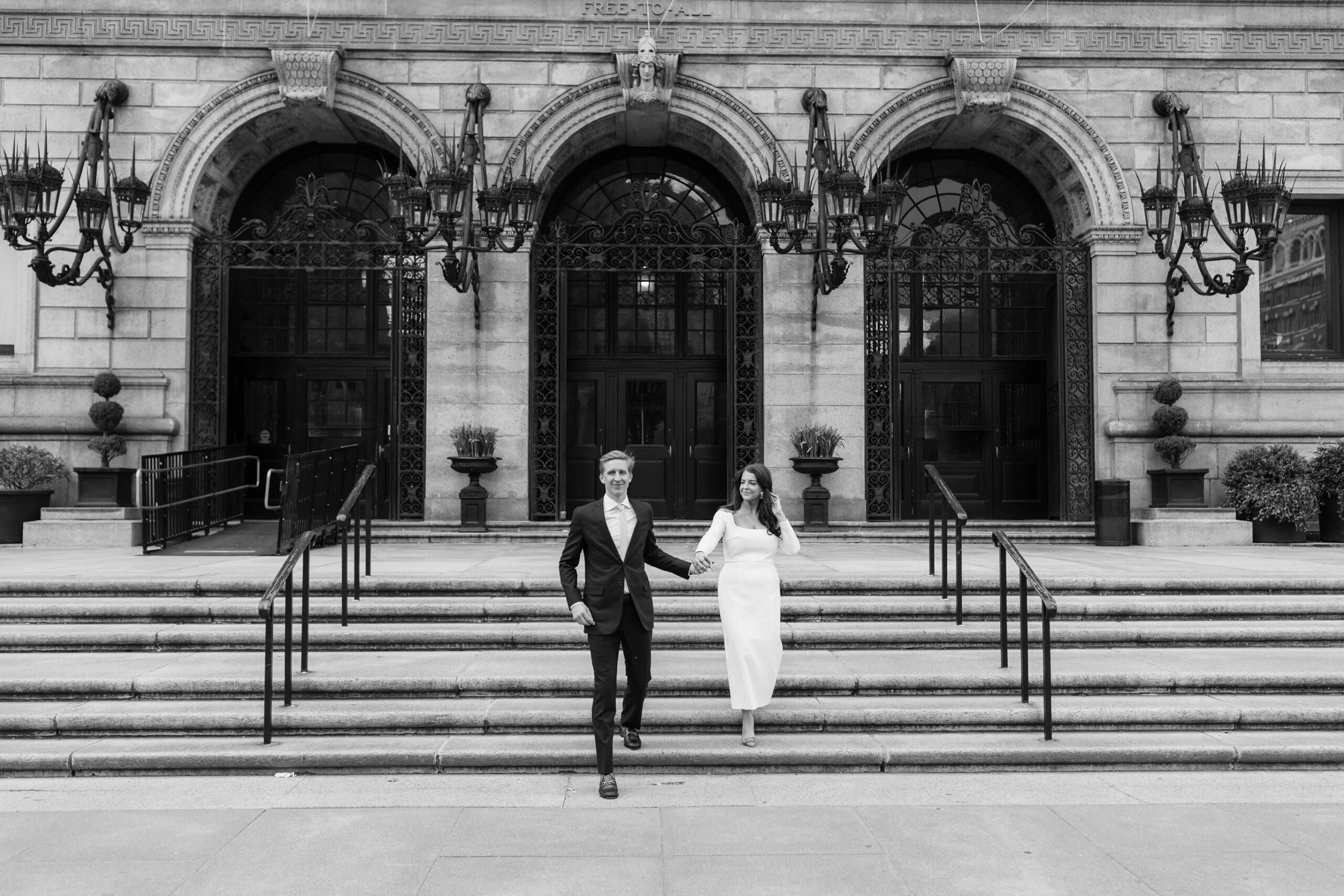 Bride and groom hold hands in Copley Square