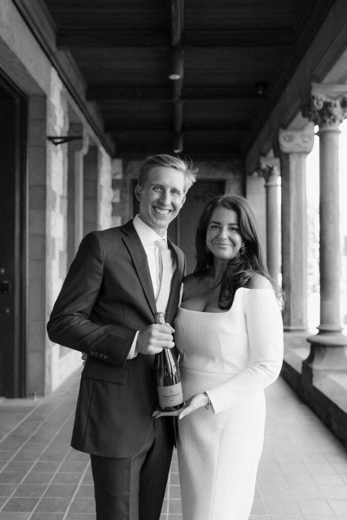 Bride and groom hold a bottle of champagne after their Boston elopement ceremony