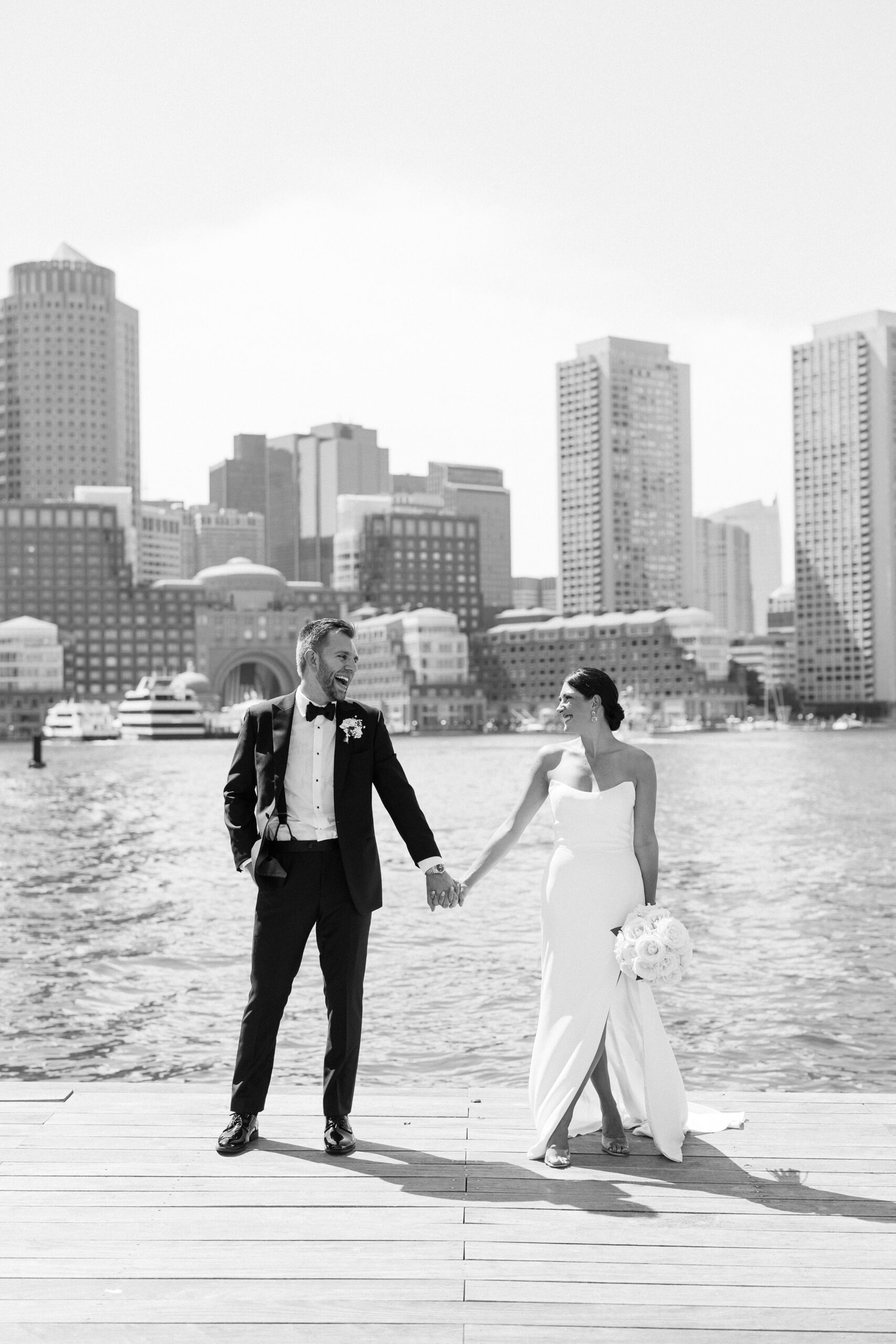Bride and groom hold hands at Boston Seaport