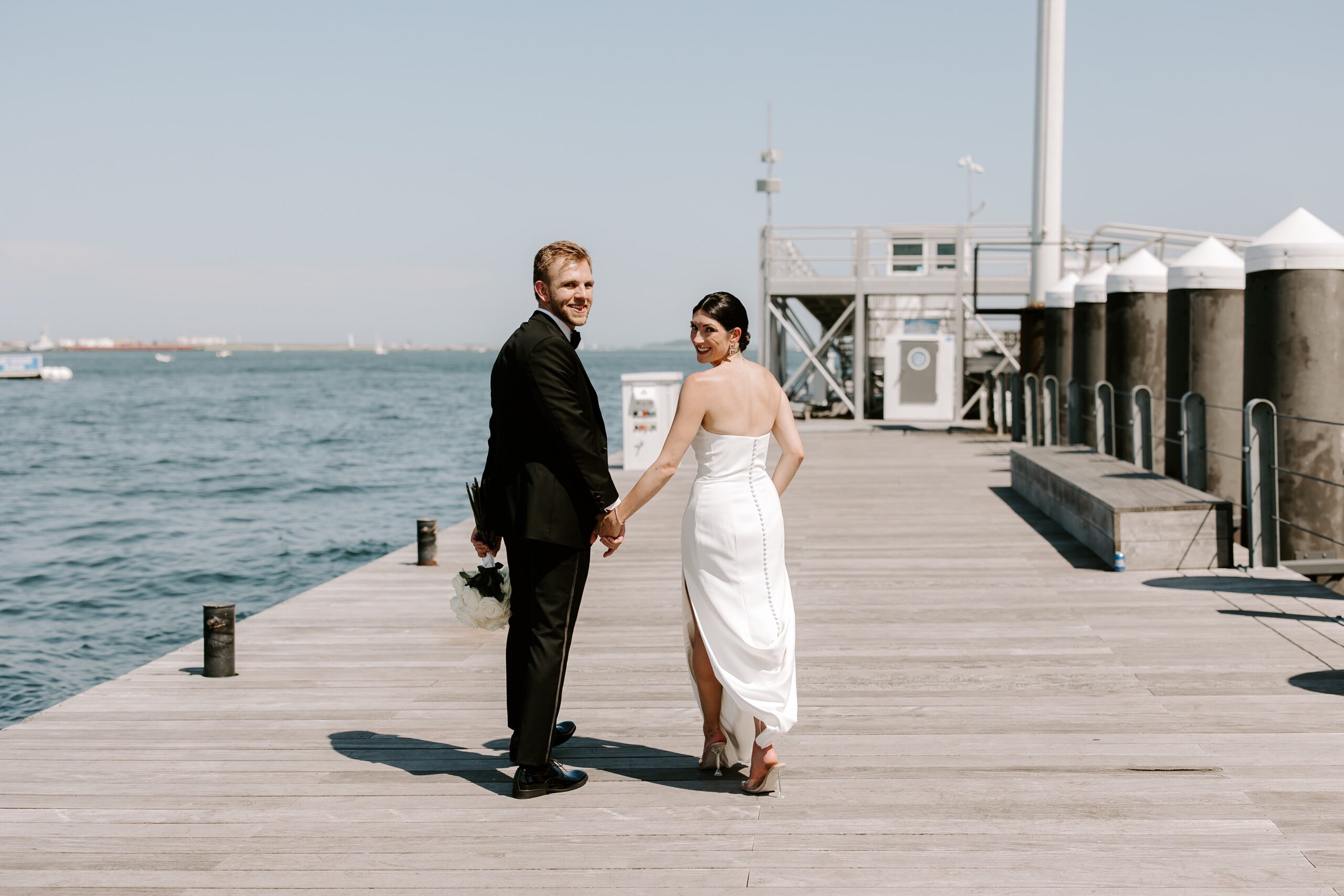 Bride and groom hold hands at Boston Seaport