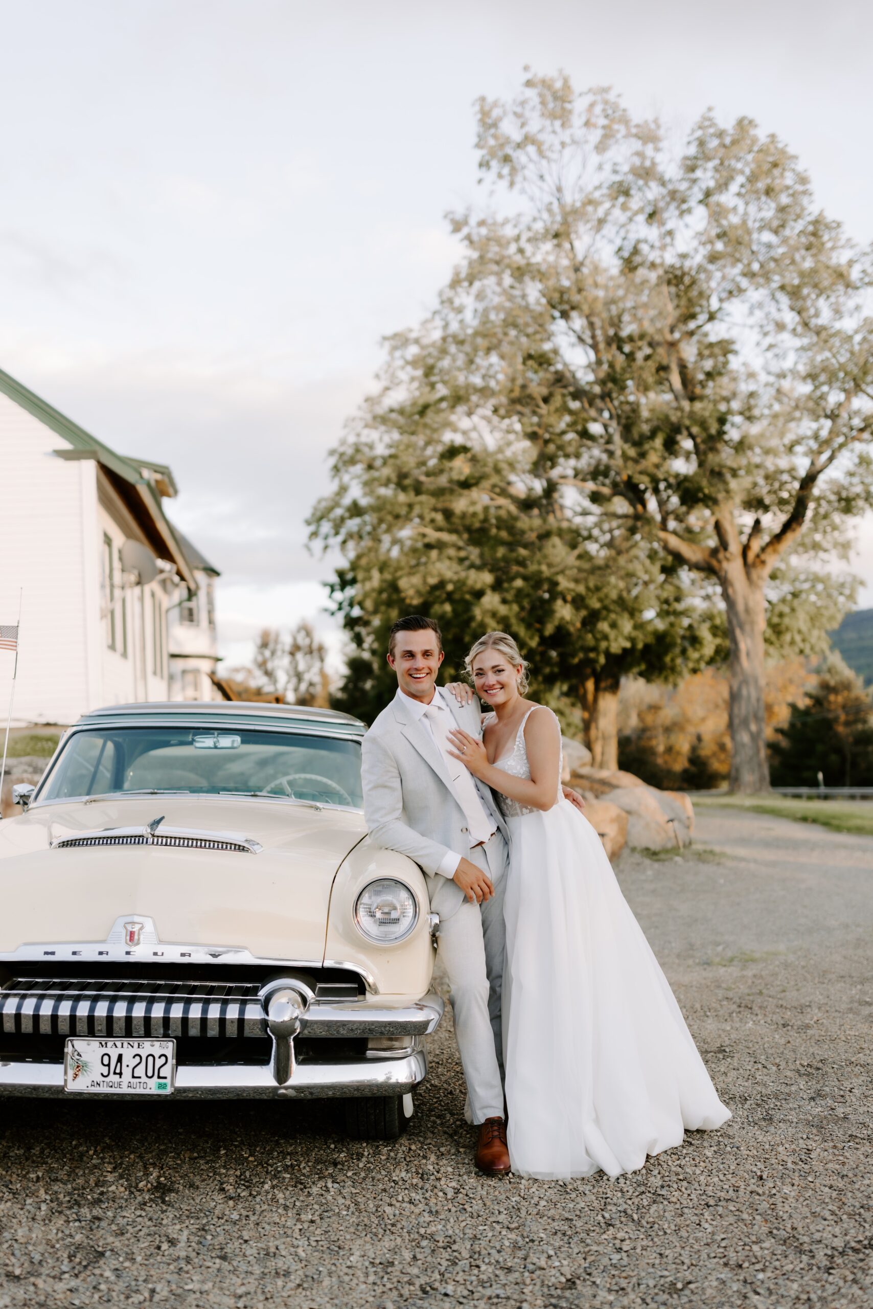 Bride and groom pose with vintage car at Mountain Star Estate