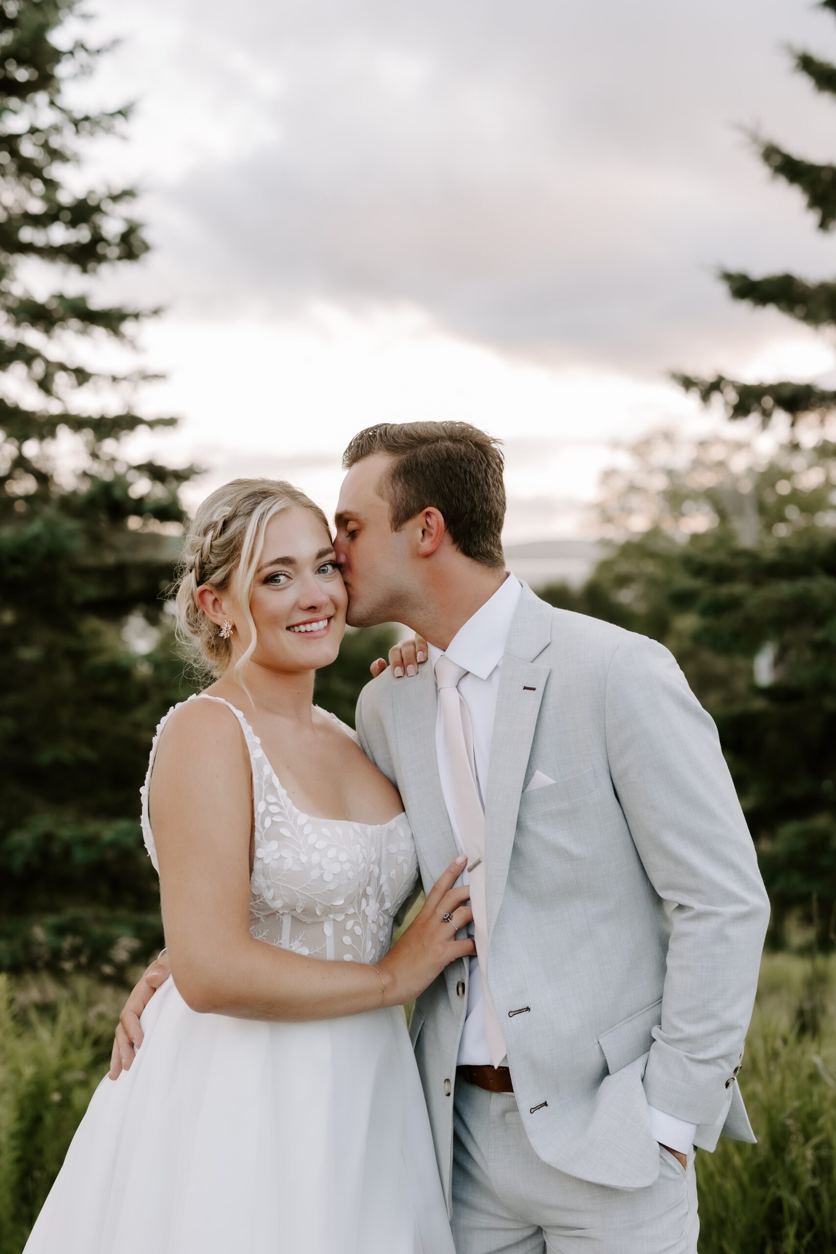 Groom kisses bride during Maine wedding photos