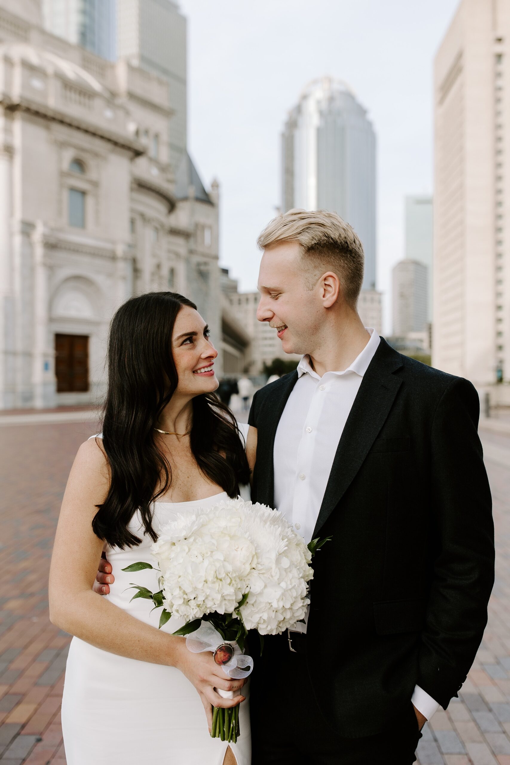 Bride and groom smile at each other in Boston