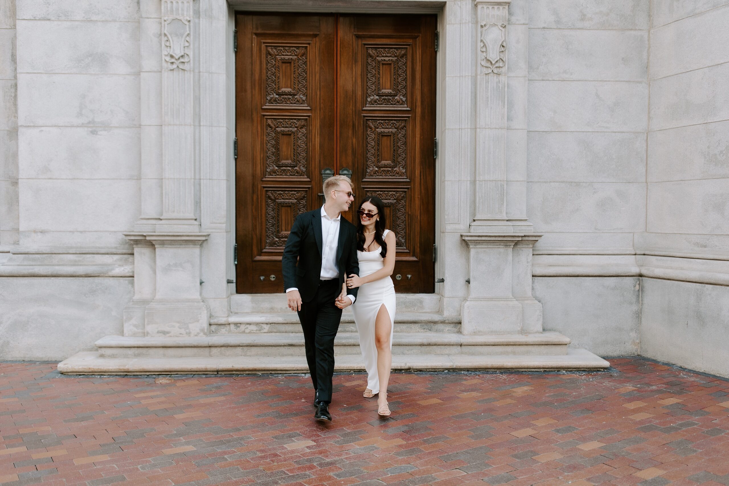 Bride and groom walking in Boston while wearing sunglasses
