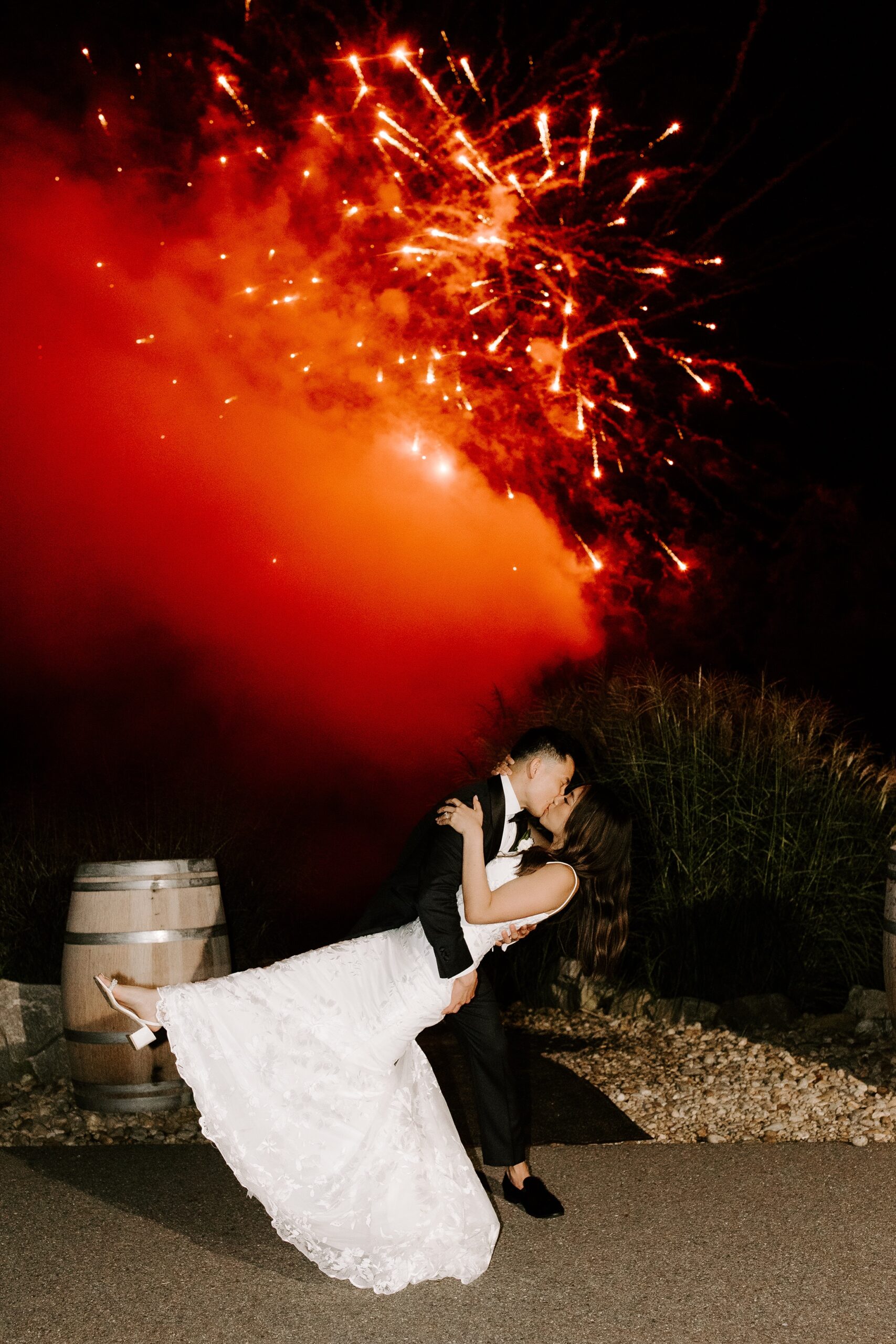 Bride and groom kiss under fireworks