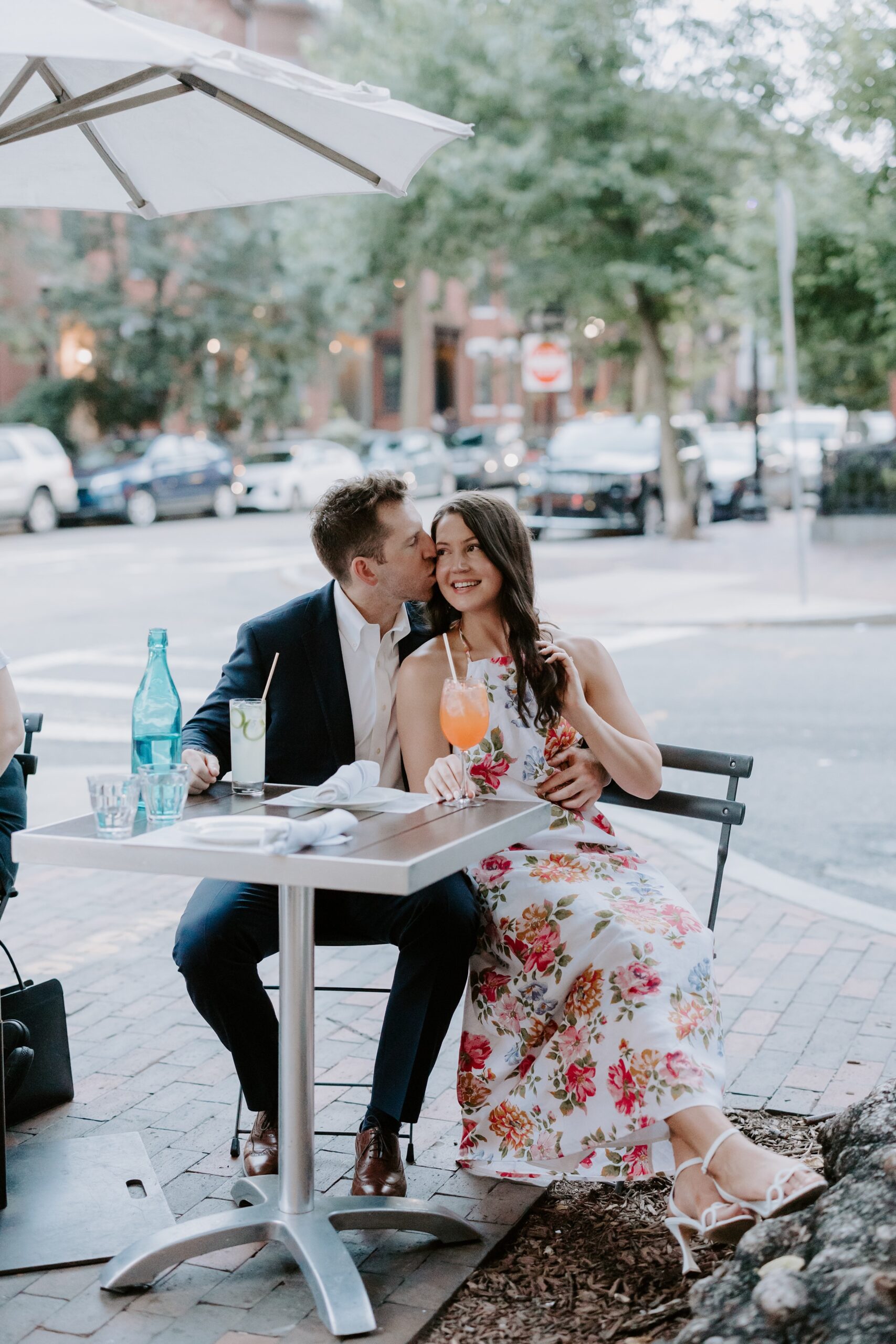 Man and woman enjoy drinks during their Boston engagement photos