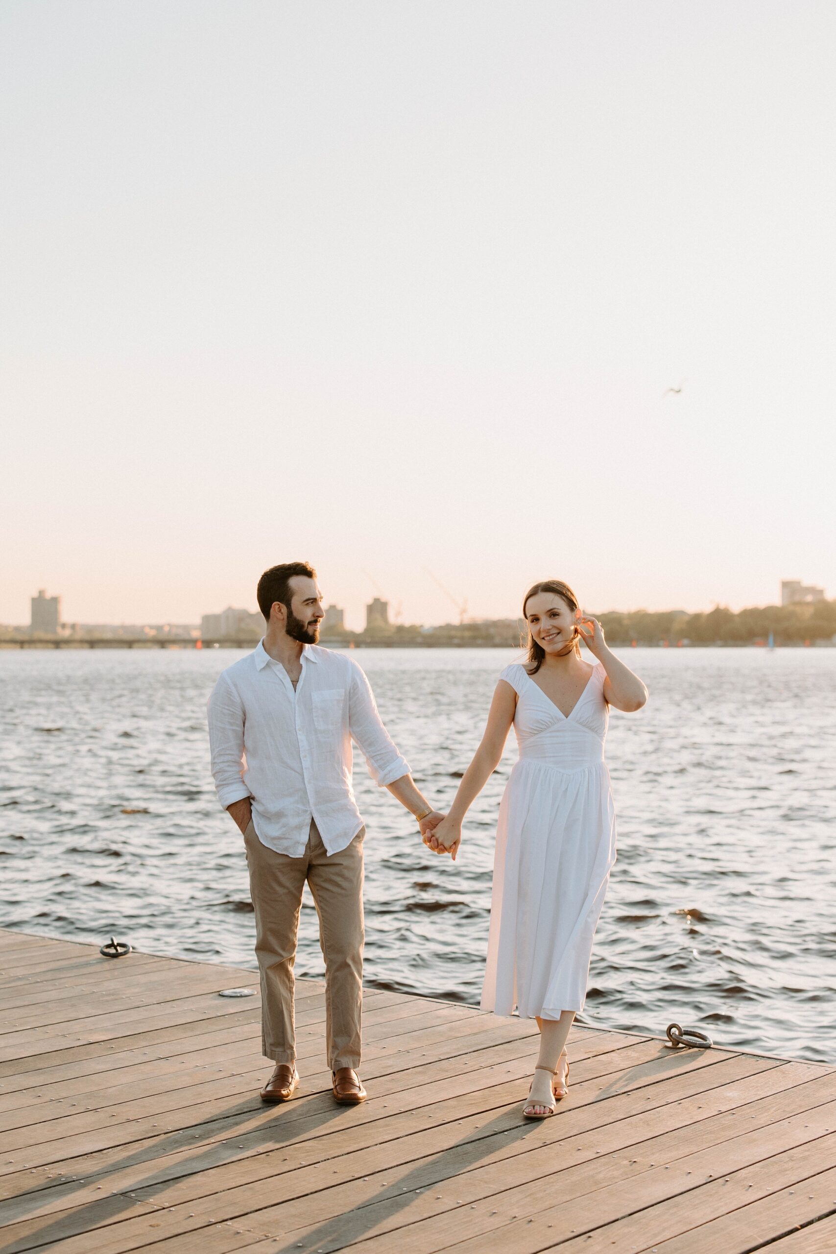 Man and woman walk holding hands at Boston Esplanade