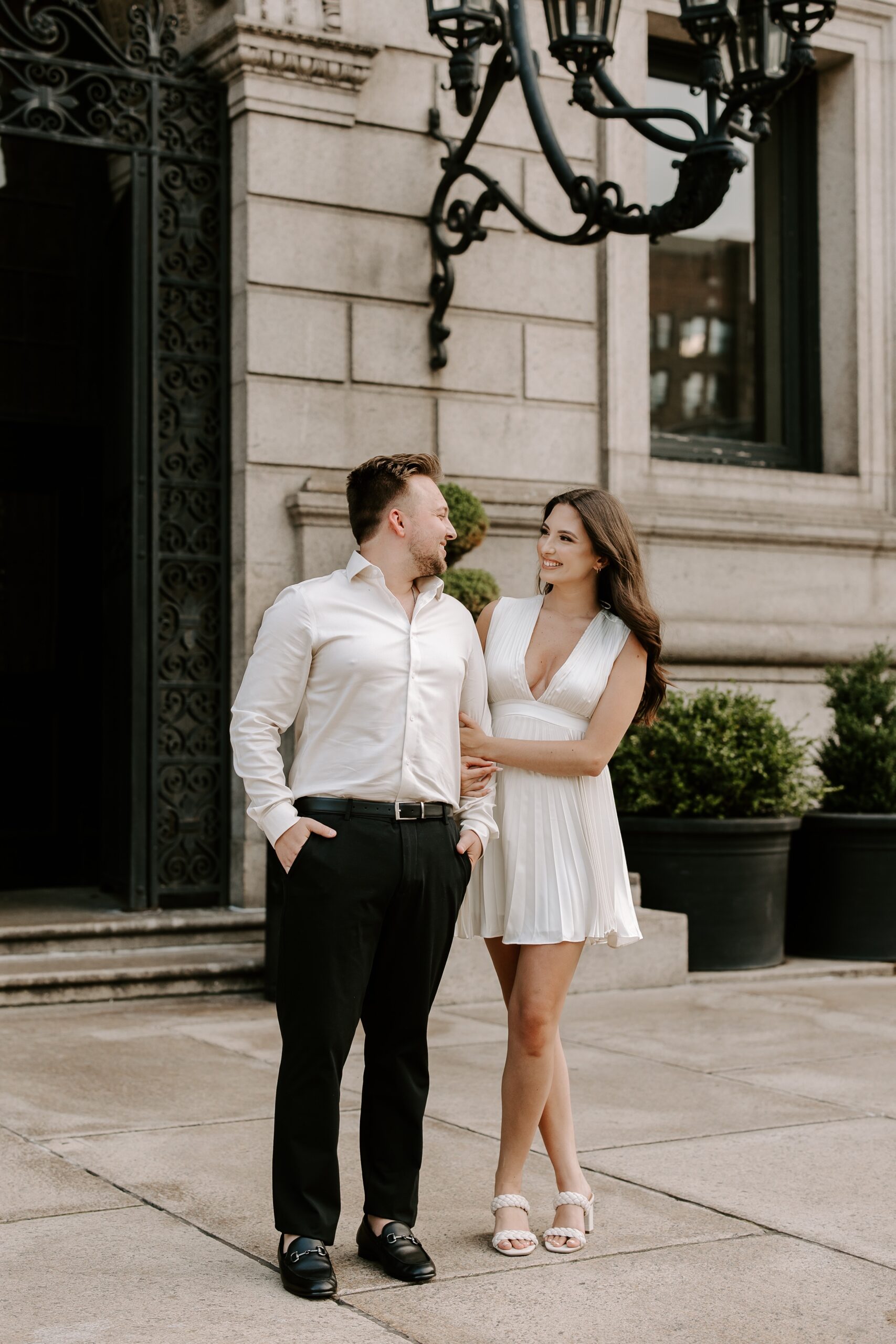 Couple smiles at each other during Boston Public Library engagement photos