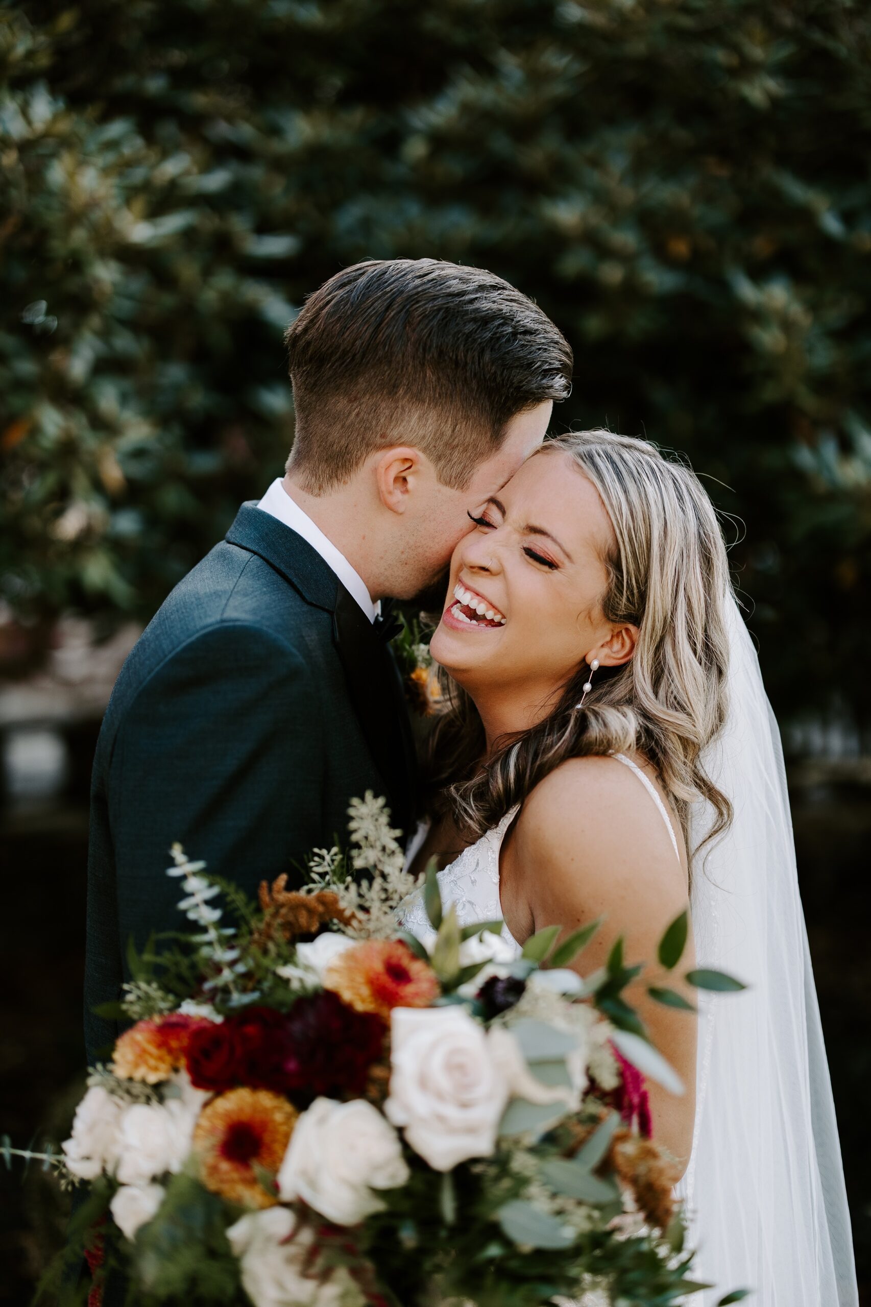 groom and bride holding fall bouquet