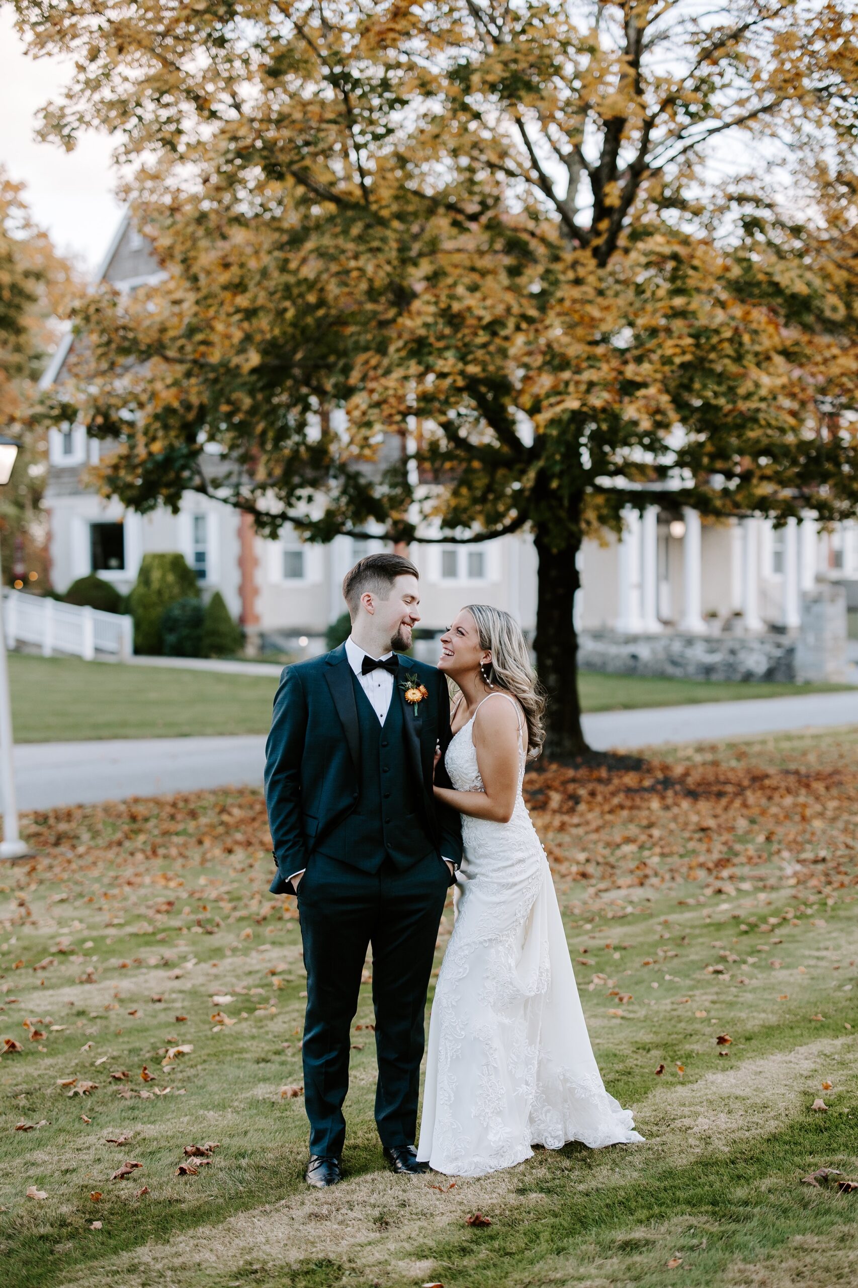 bride and groom in front of fall leaves