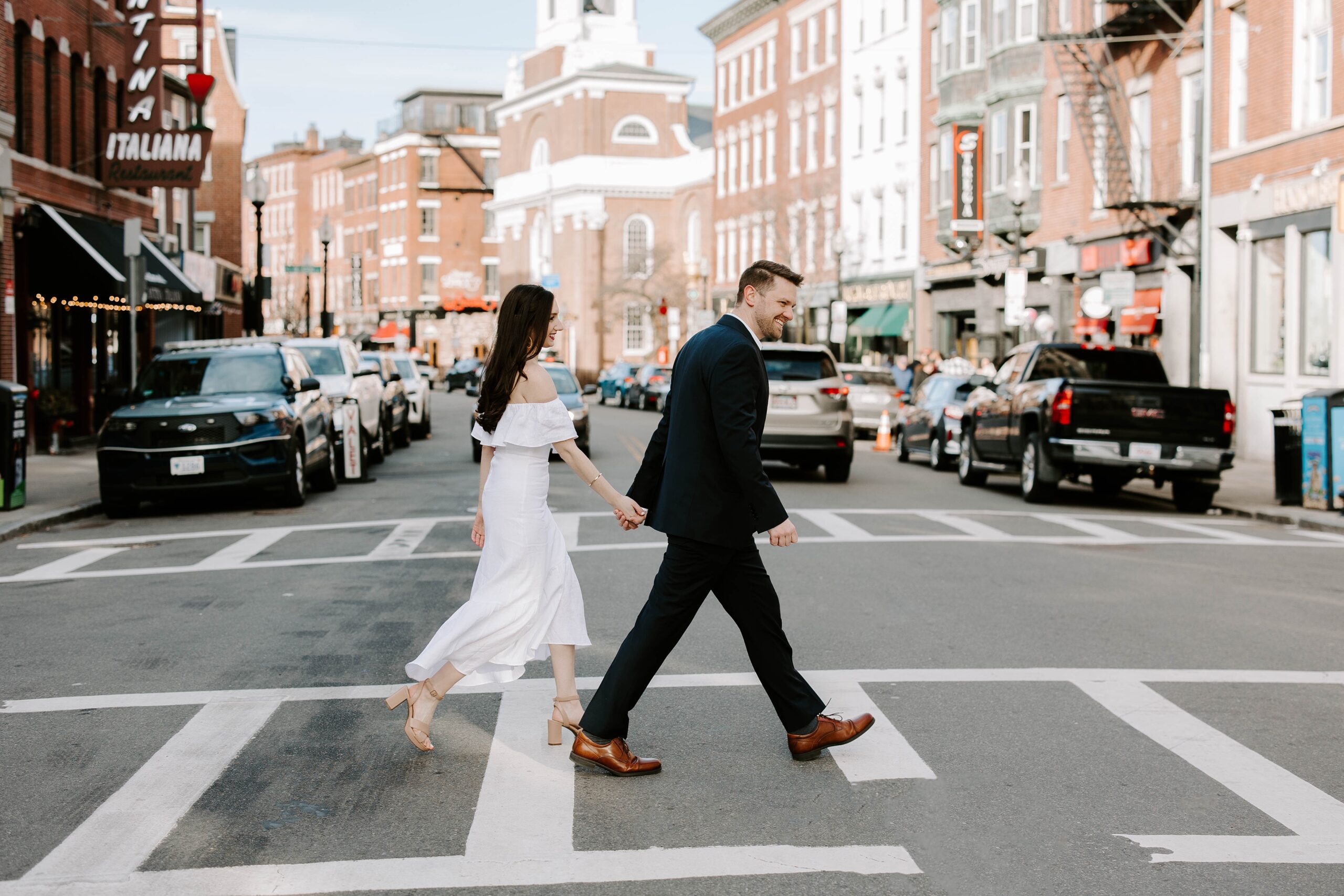 Man and woman cross the street during North End engagement photos