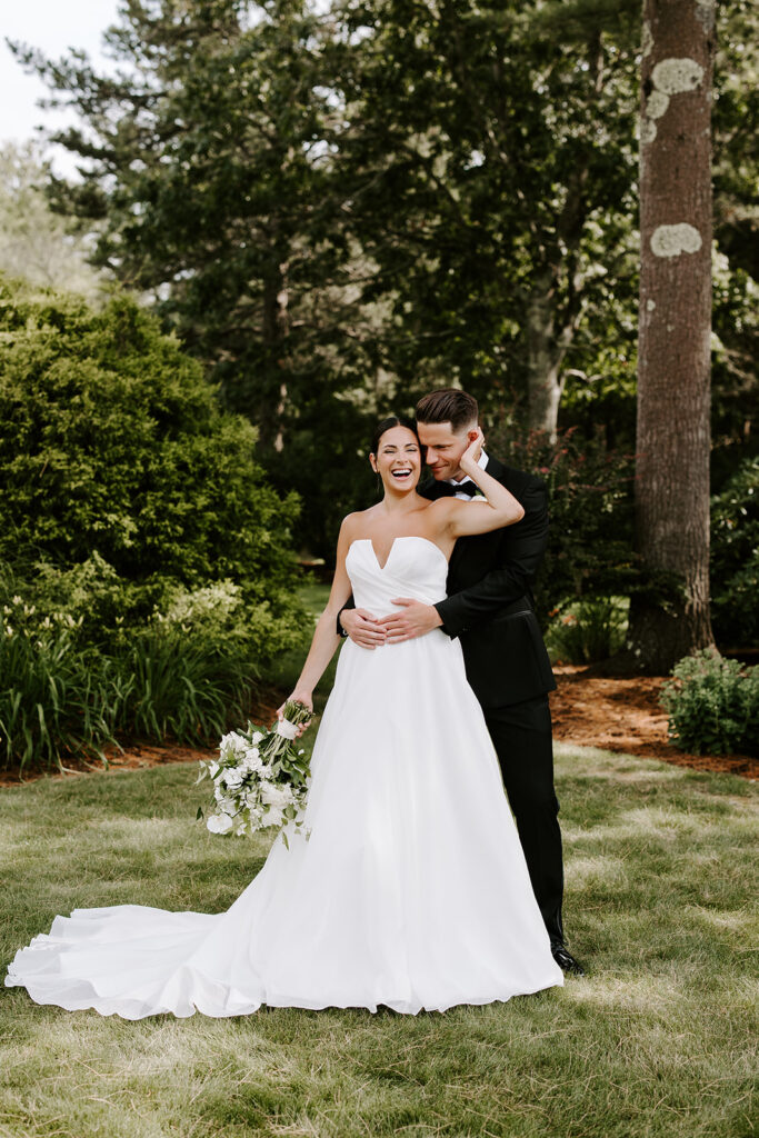 Beautiful bride and groom pose on the lawn outside their dreamy wedding day