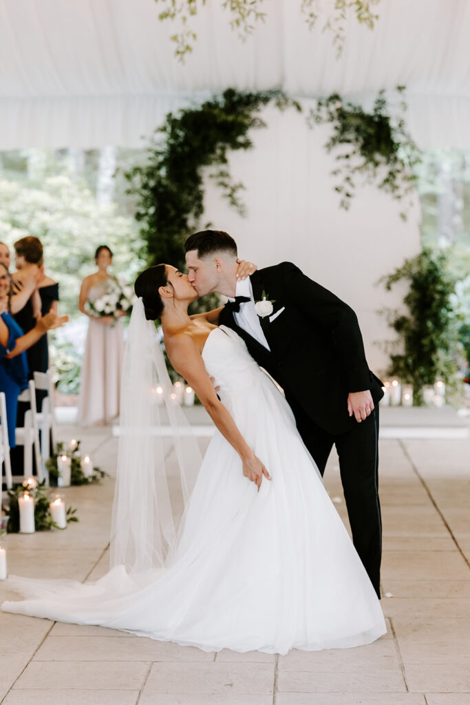 Stunning bride and groom share a kiss as they exit their wedding ceremony