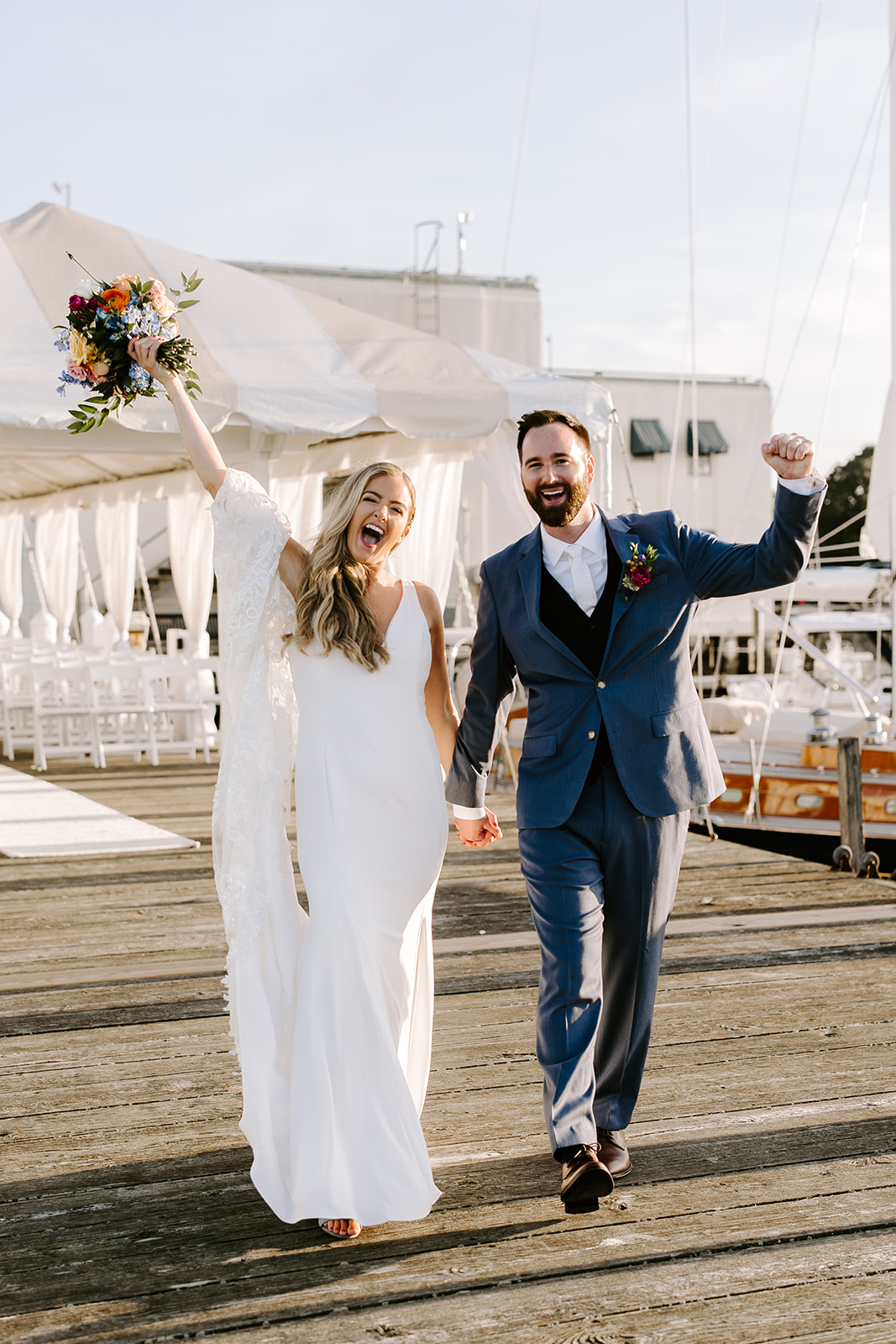 Gorgeous bride and groom pose on the docks after their dreamy New England wedding venue