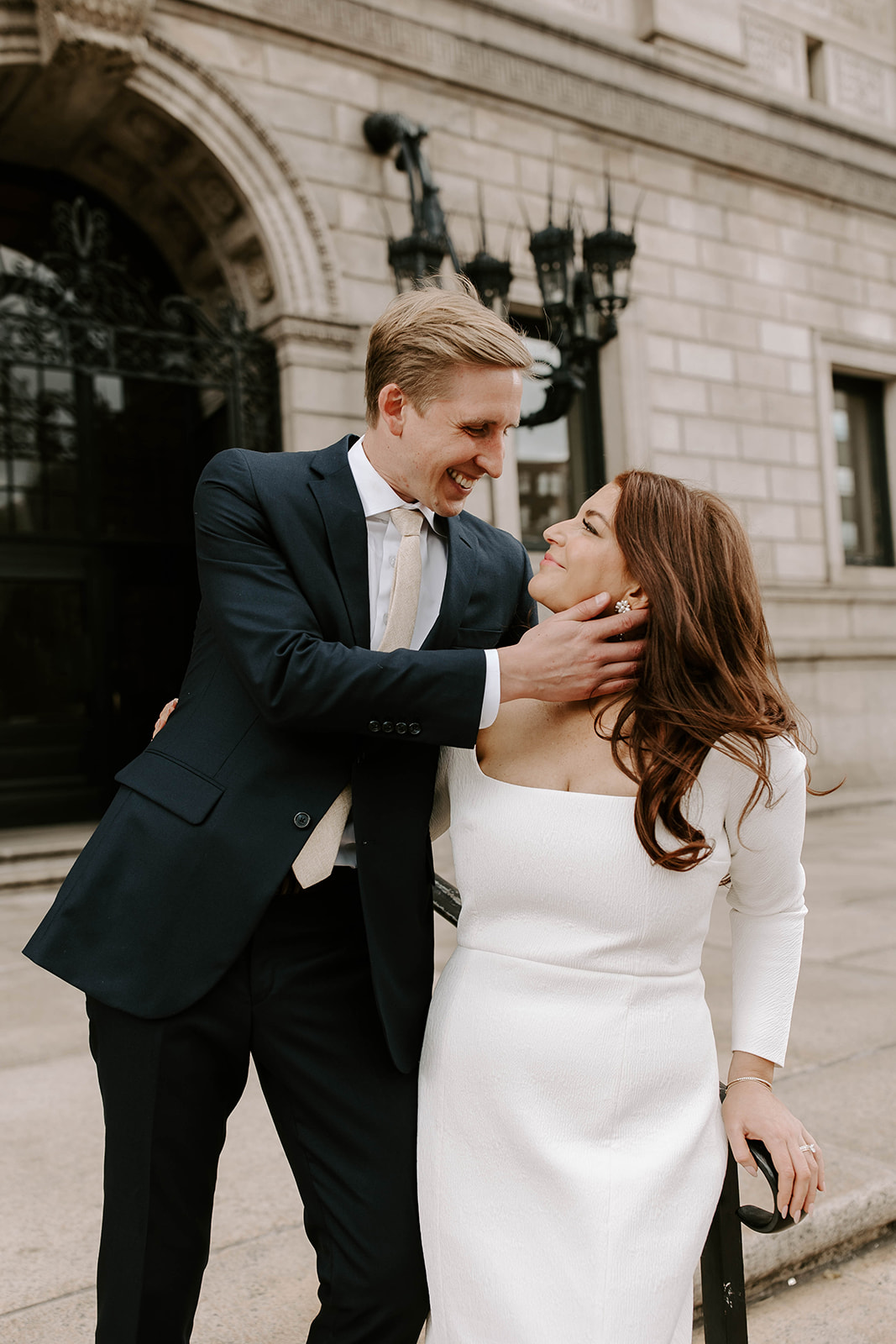 Stunning bride and groom pose together in front of the Boston public library