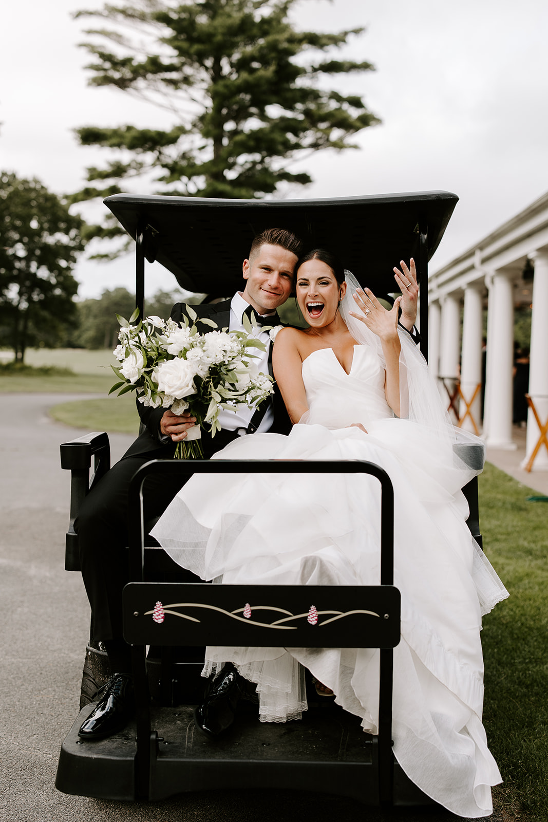 bride and groom riding on golf cart at pinehills golf club 