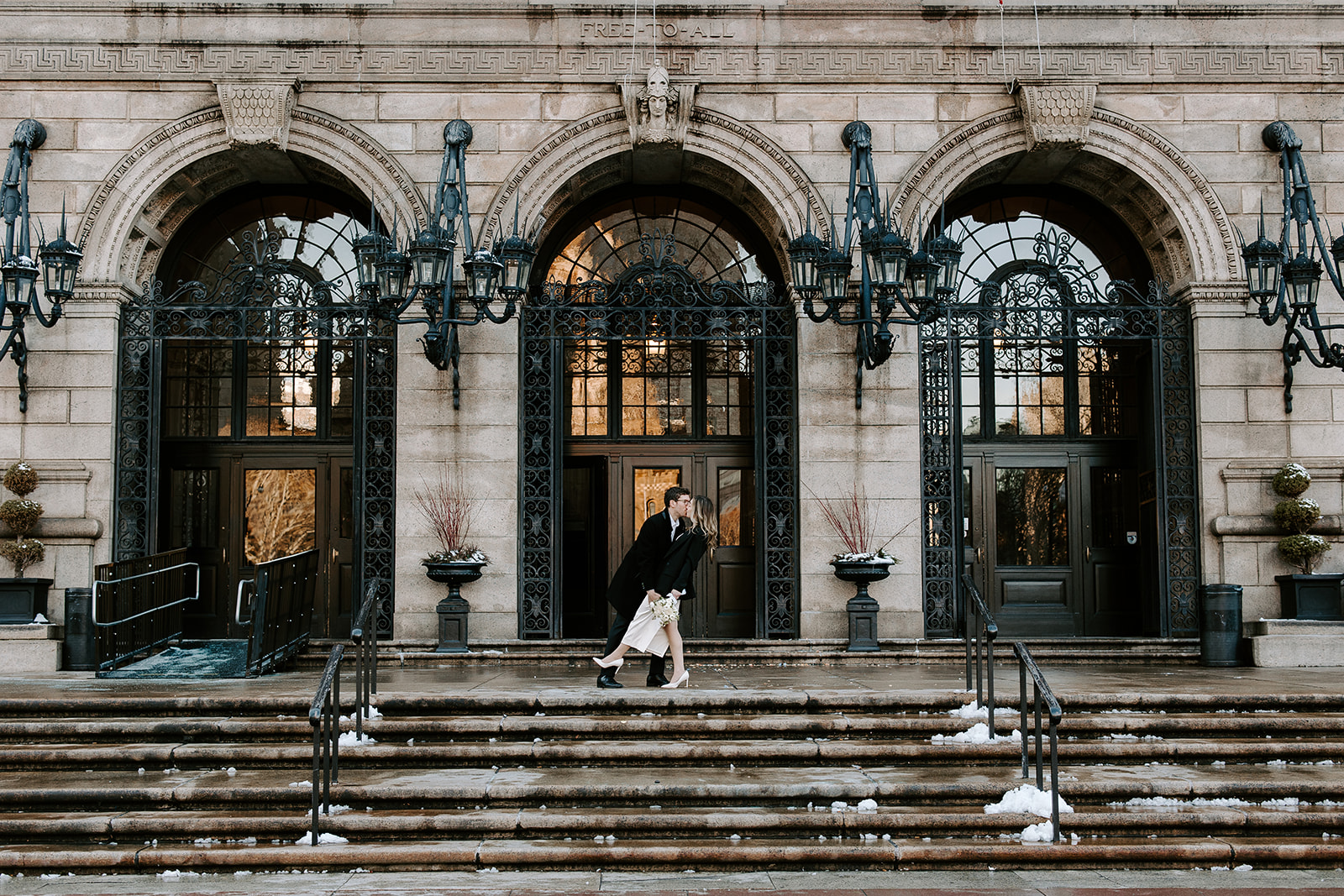 Bride and groom pose together outside the stunning Boston public library