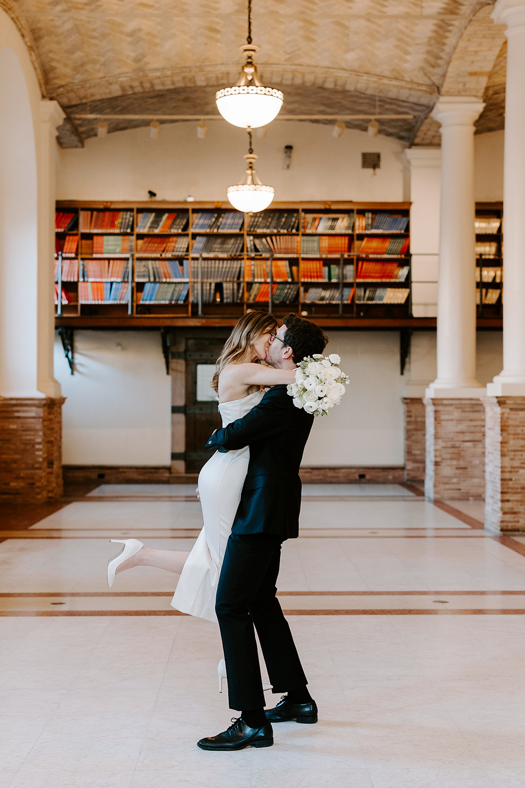 Stunning couple pose in the Boston public library after their dreamy winter elopement
