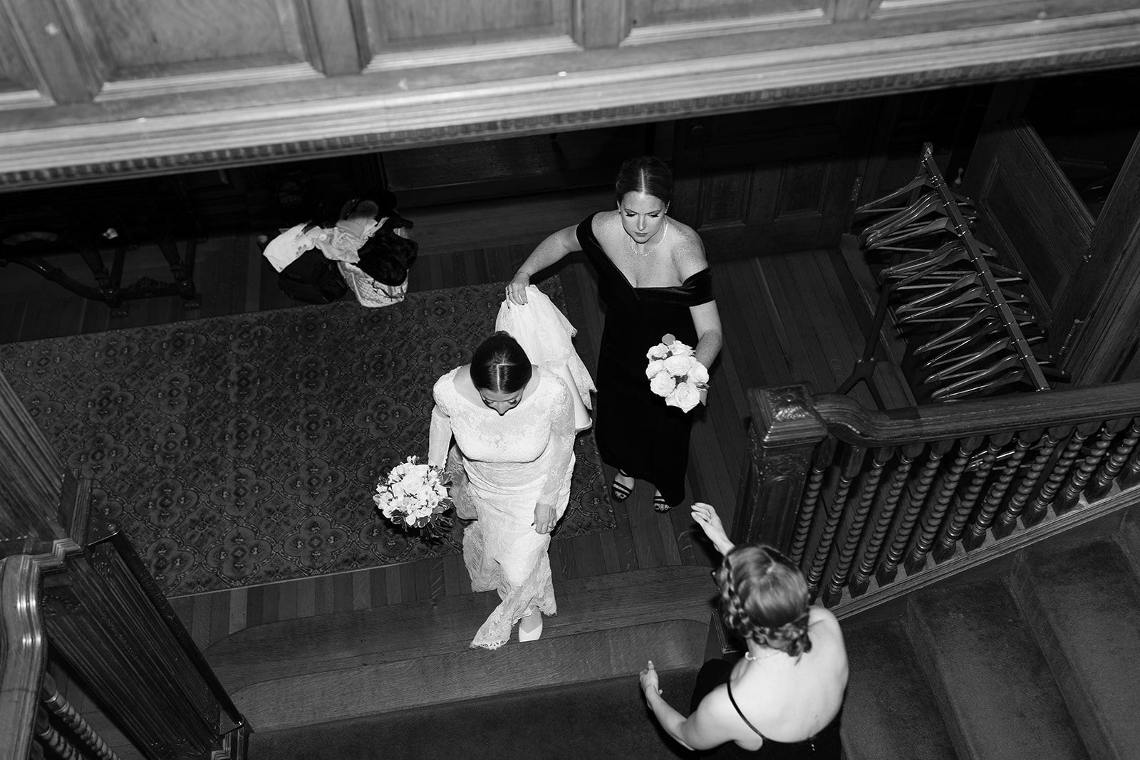 Stunning bride and and bridesmaids come up the stairs towards the elegant wedding ceremony