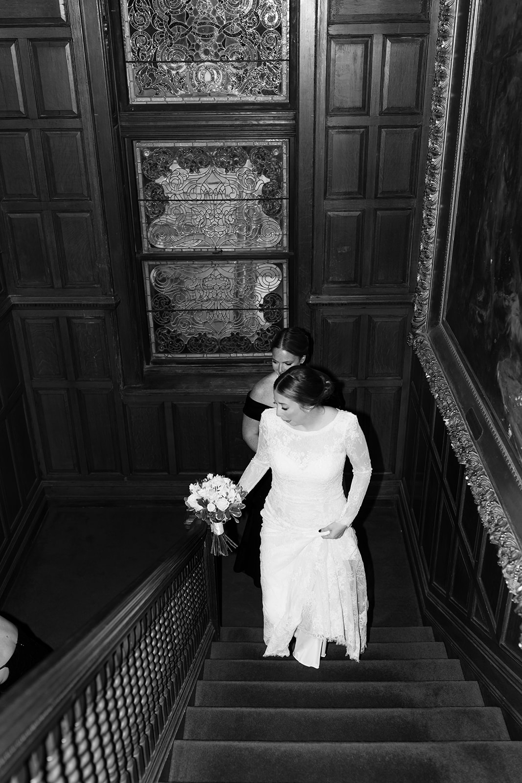 Stunning bride and and bridesmaids come up the stairs towards the elegant wedding ceremony
