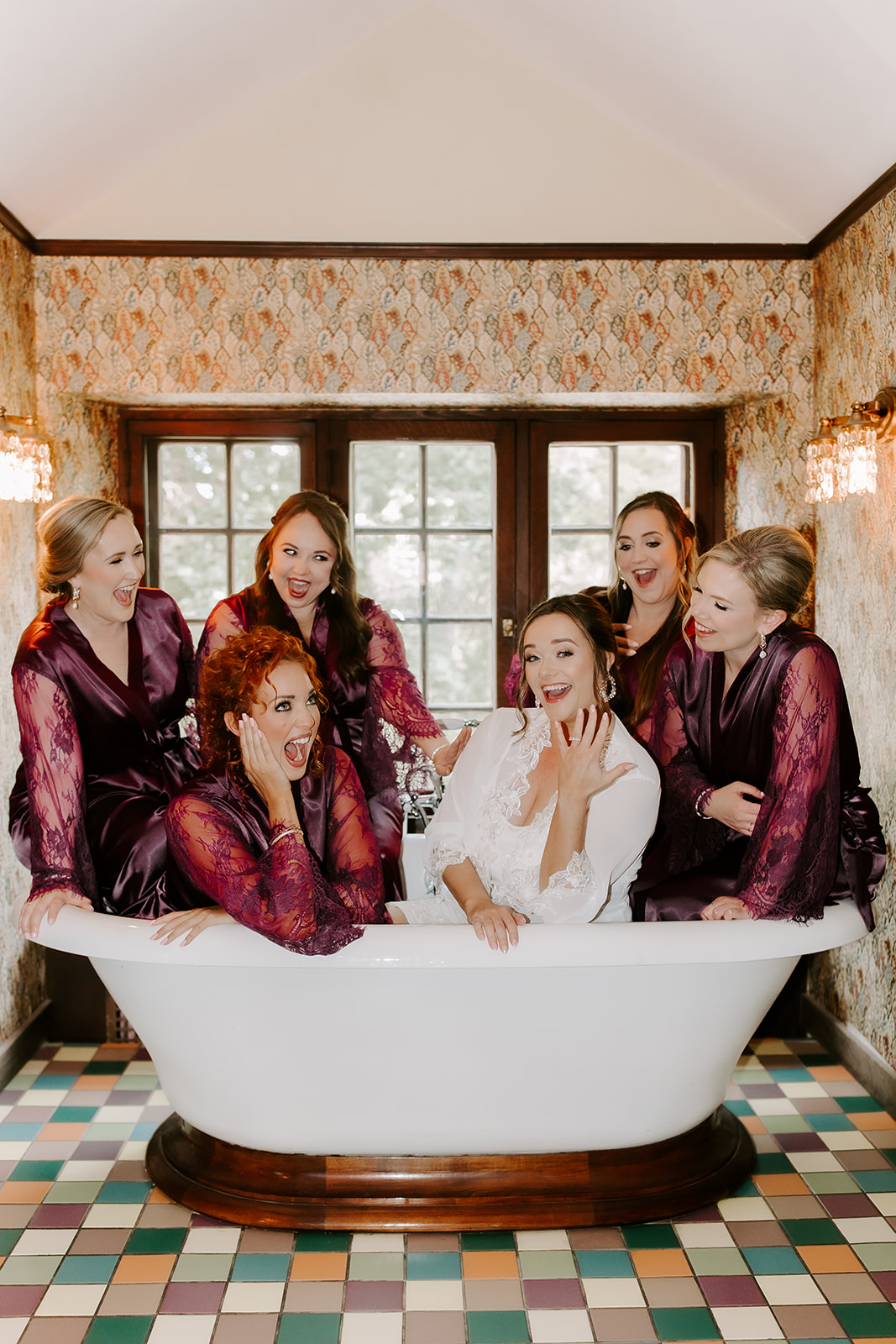 bride and bridesmaids pose in the bathroom to snap pictures are they prepare for the stunning willowdale estate wedding
