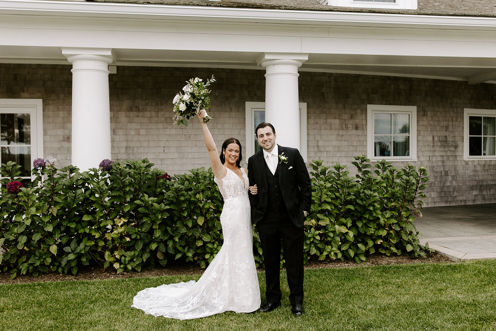 Stunning bride and groom pose in front of their dreamy wedding venue together