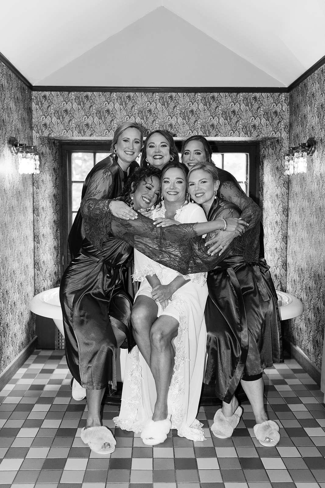 bride and bridesmaids pose in the bathroom to snap pictures are they prepare for the stunning willowdale estate wedding