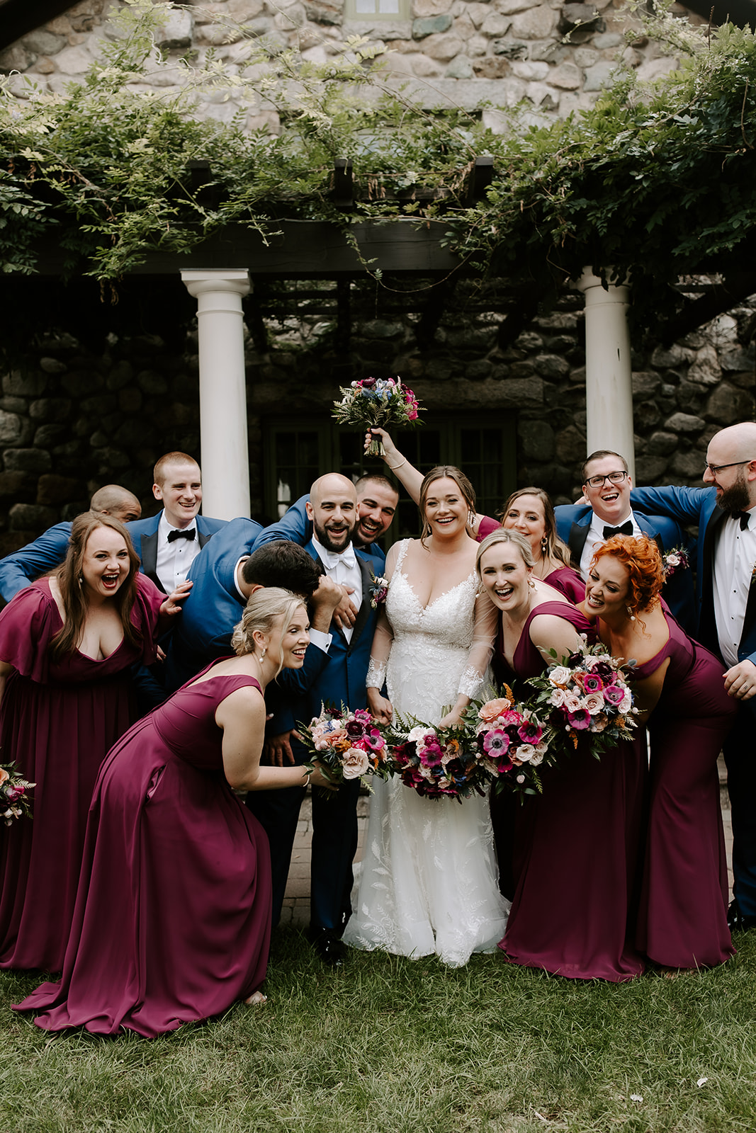 the whole wedding party poses together as everyone cheers