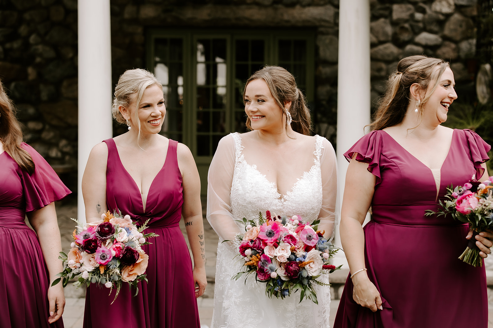 bride and bridesmaids pose together with their bouquets 