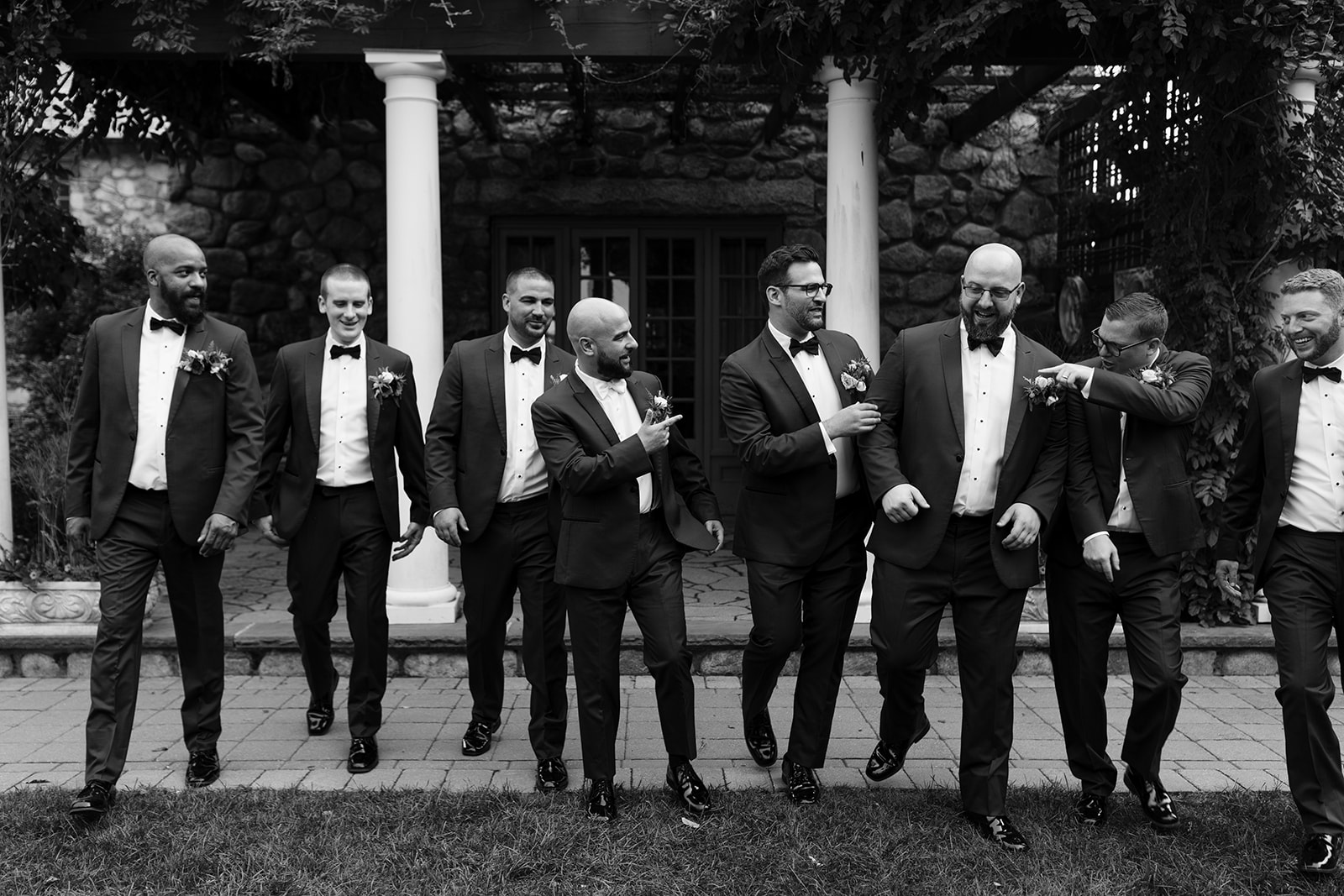 groom and groomsmen pose together sharing a laugh