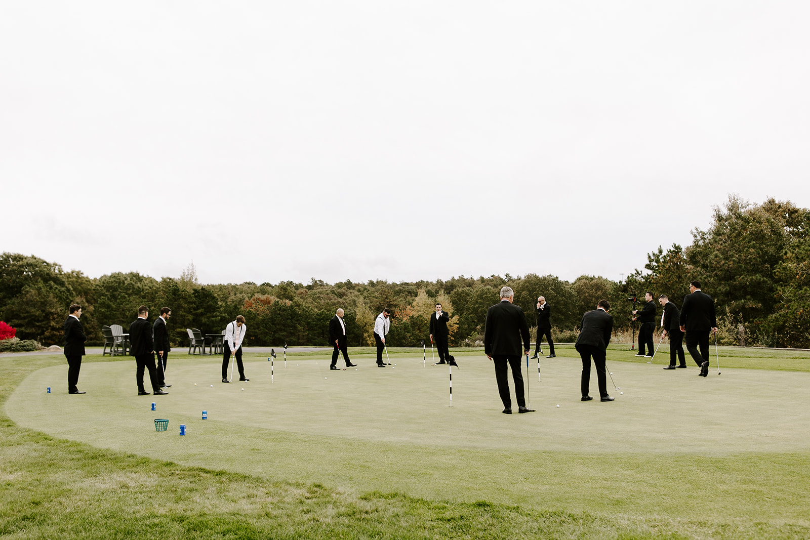 Groomsmen play golf before the stunning New England wedding day