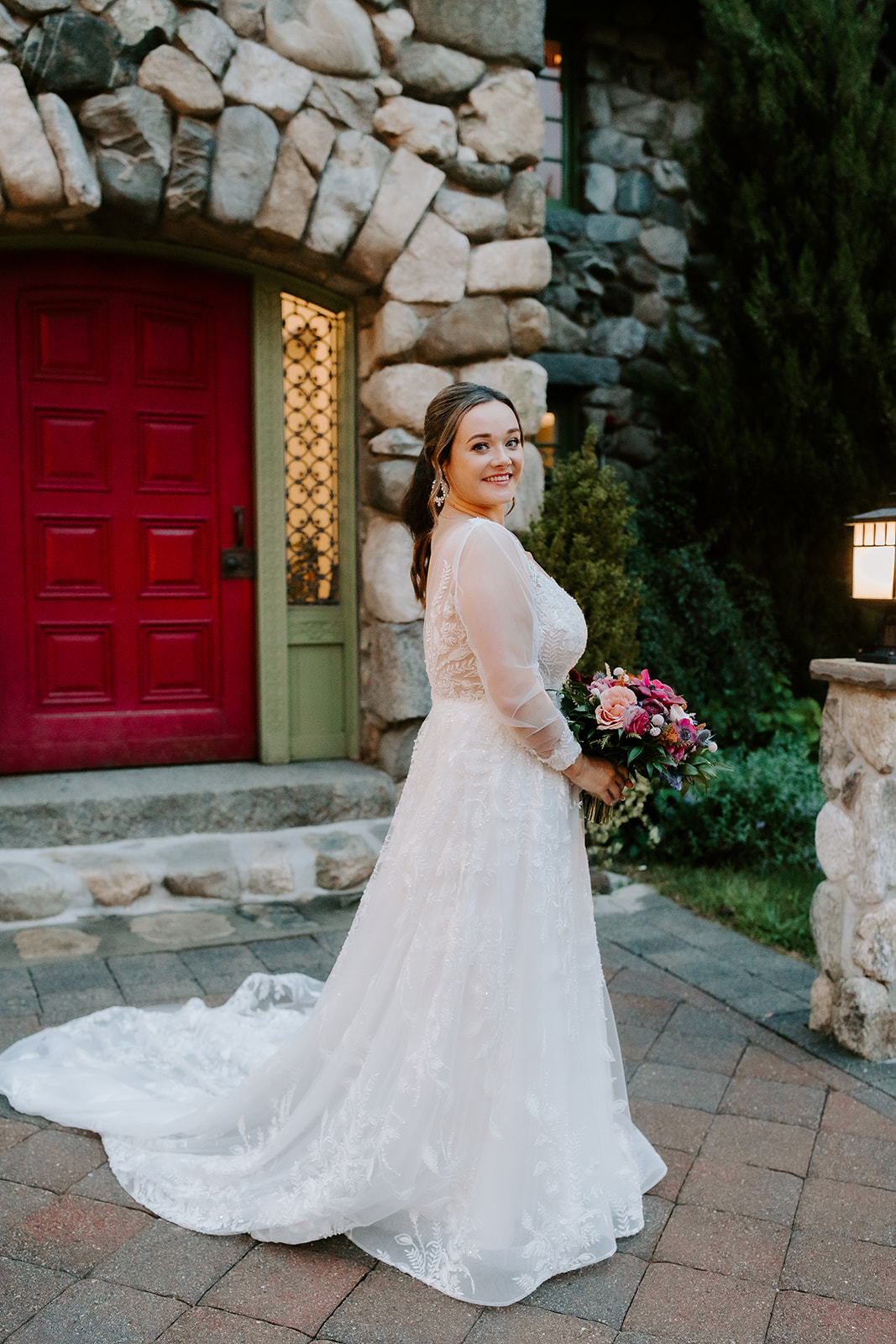 bride poses outside with the stunning stone in the background