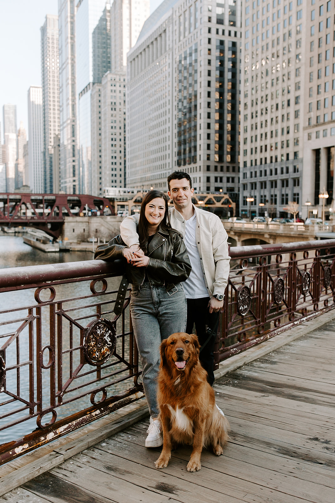 stunning couple pose with their dog and the skyline during their Chicago engagement photos 
