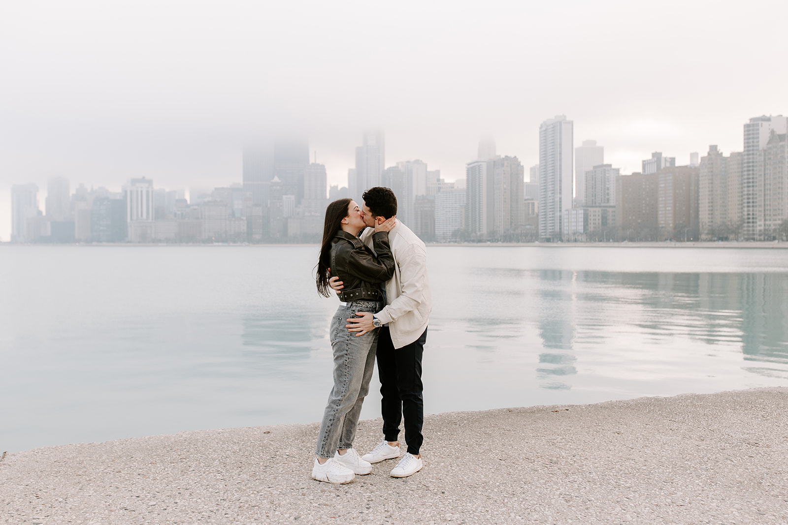beautiful couple share a romantic kiss with Chicago in the background