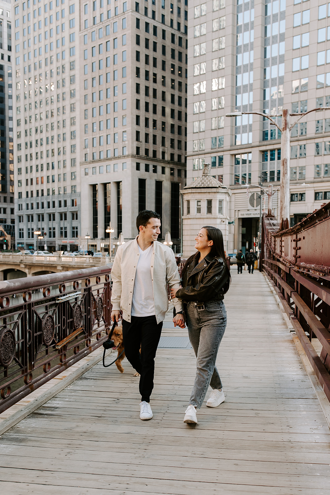 stunning couple walk together with the Chicago in the background