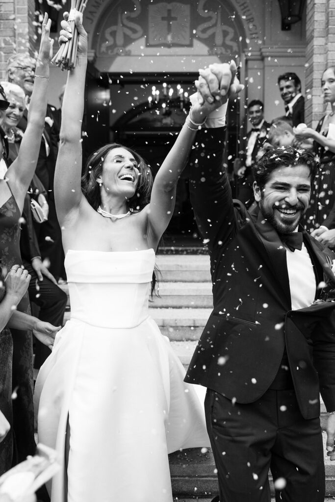 bride and groom exiting wedding ceremony with flowers thrown at them