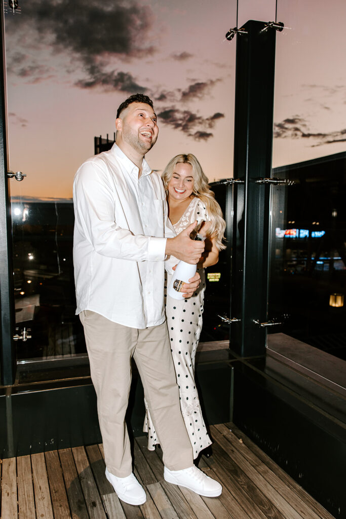 couple popping champagne